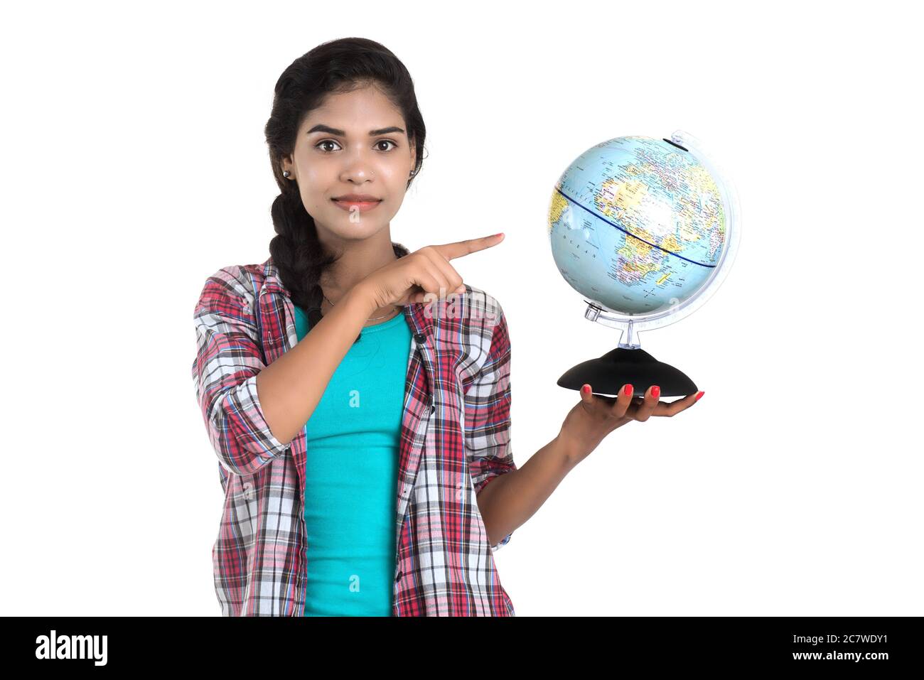 young woman holding the world globe and posing on a white background ...