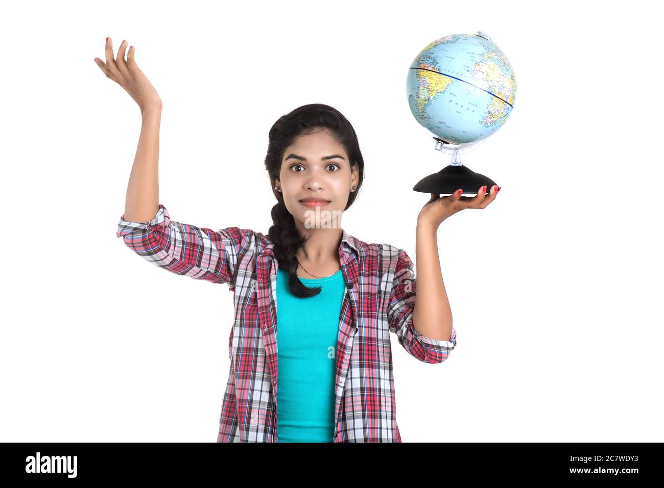 young woman holding the world globe and posing on a white background ...