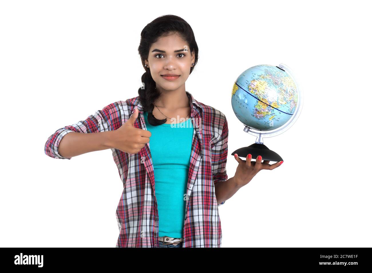 young woman holding the world globe and posing on a white background ...