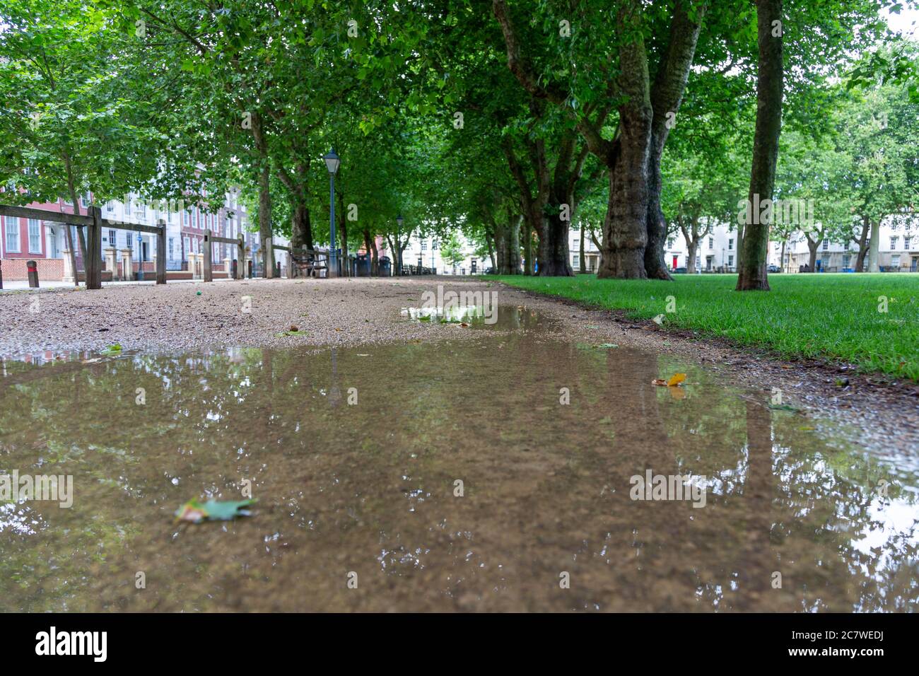 Low angle shot of the gravel footpath along the edge of Queen Square park, Bristol, UK. no people, refection in the puddle water Stock Photo