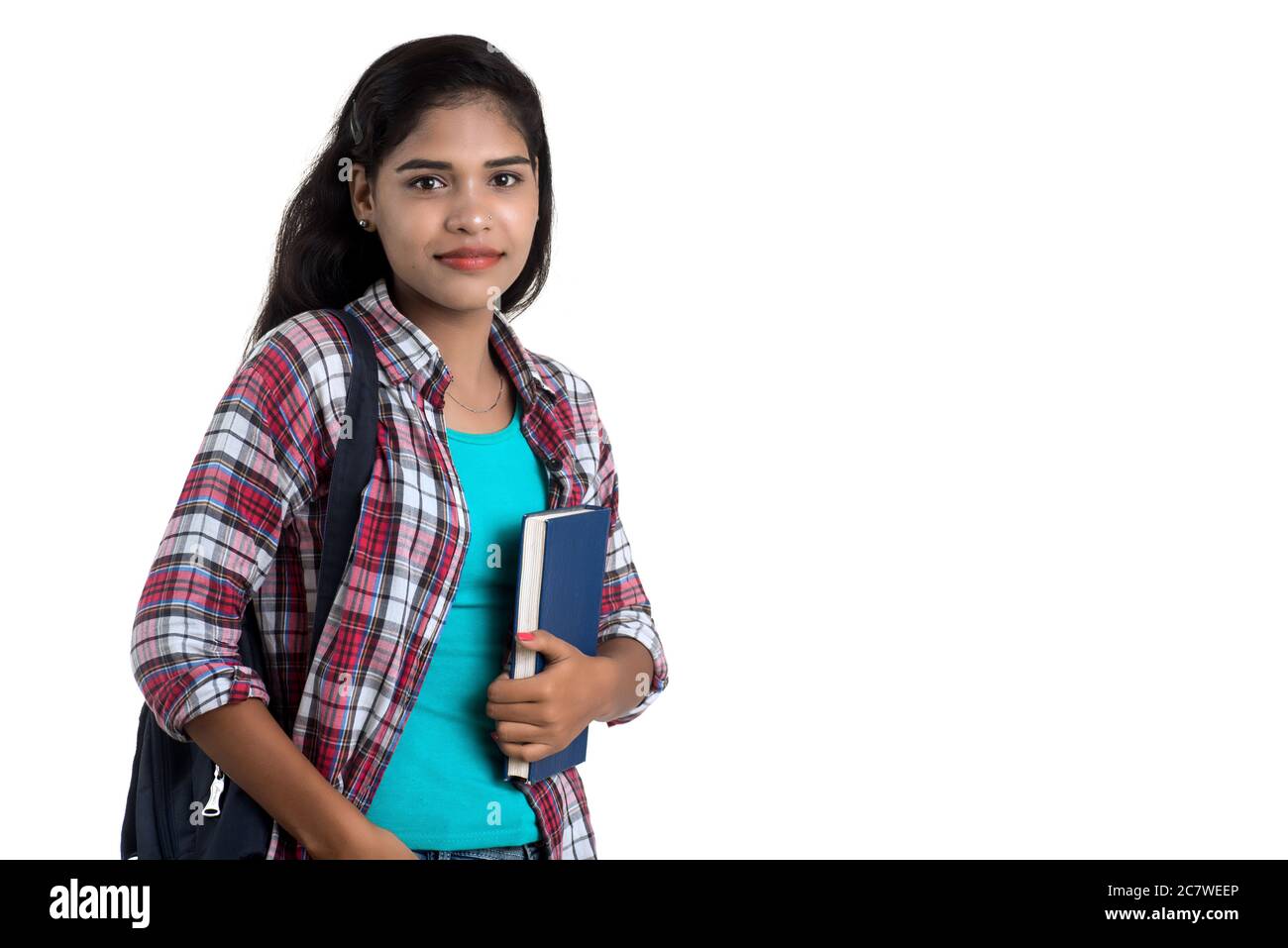 young Indian woman with backpack standing and holding notebooks, posing ...