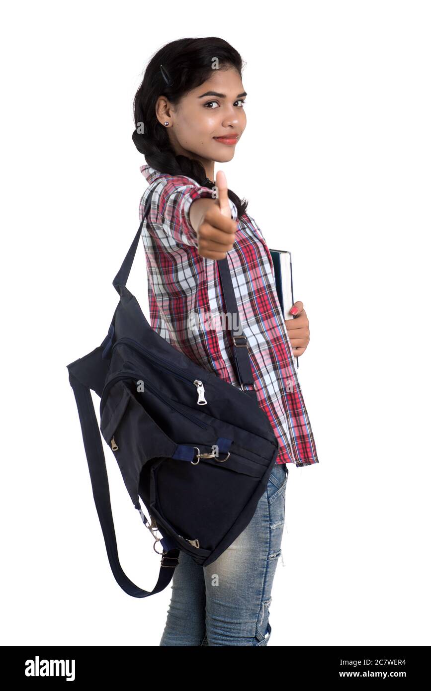 young Indian woman with backpack standing and holding notebooks, posing ...