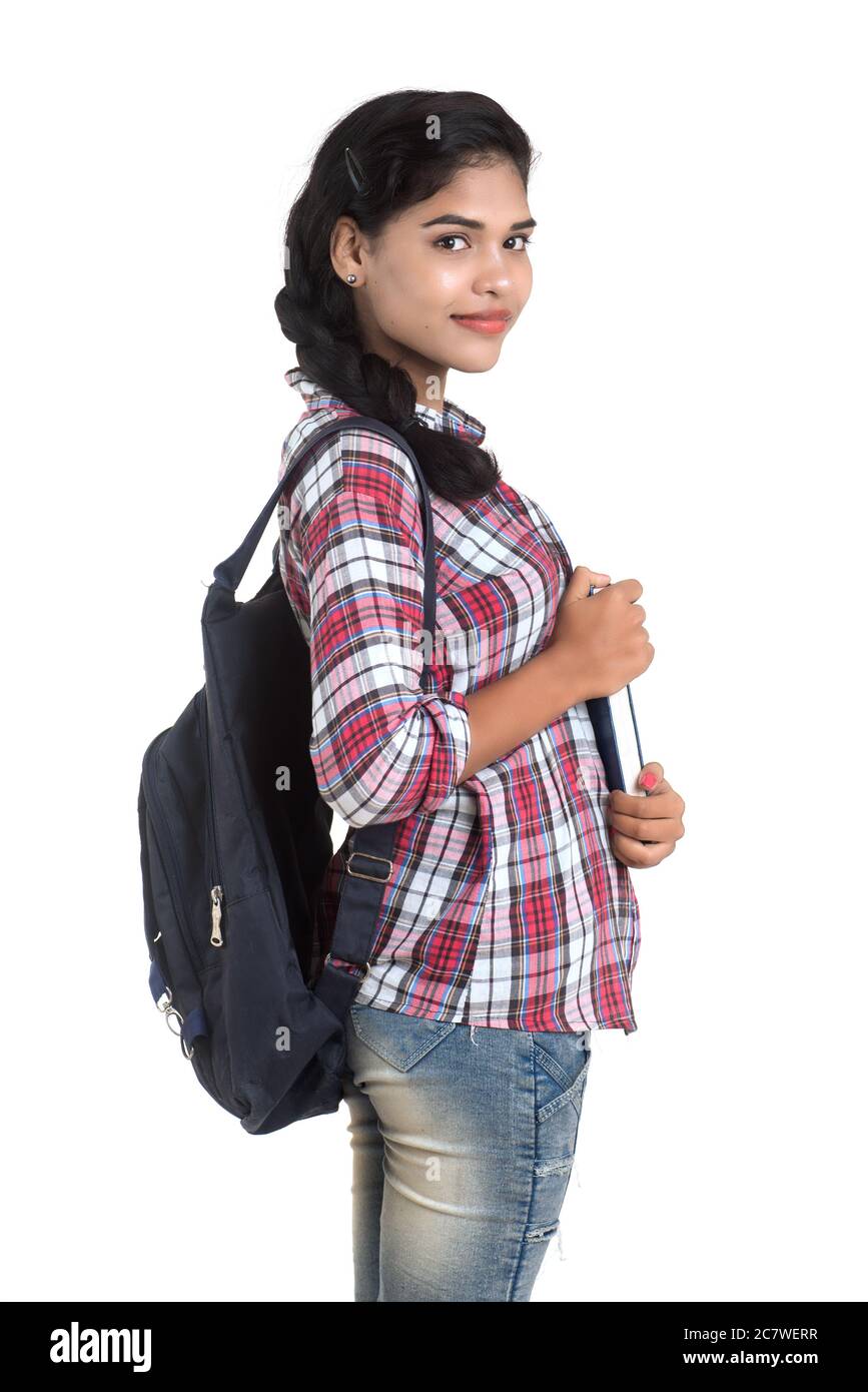 young Indian woman with backpack standing and holding notebooks, posing ...