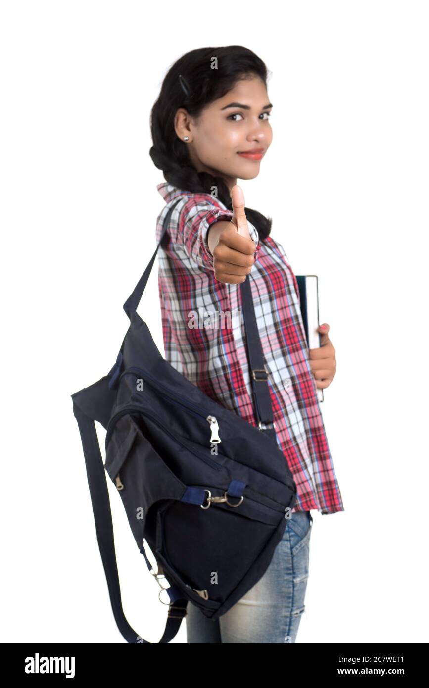 young Indian woman with backpack standing and holding notebooks, posing ...