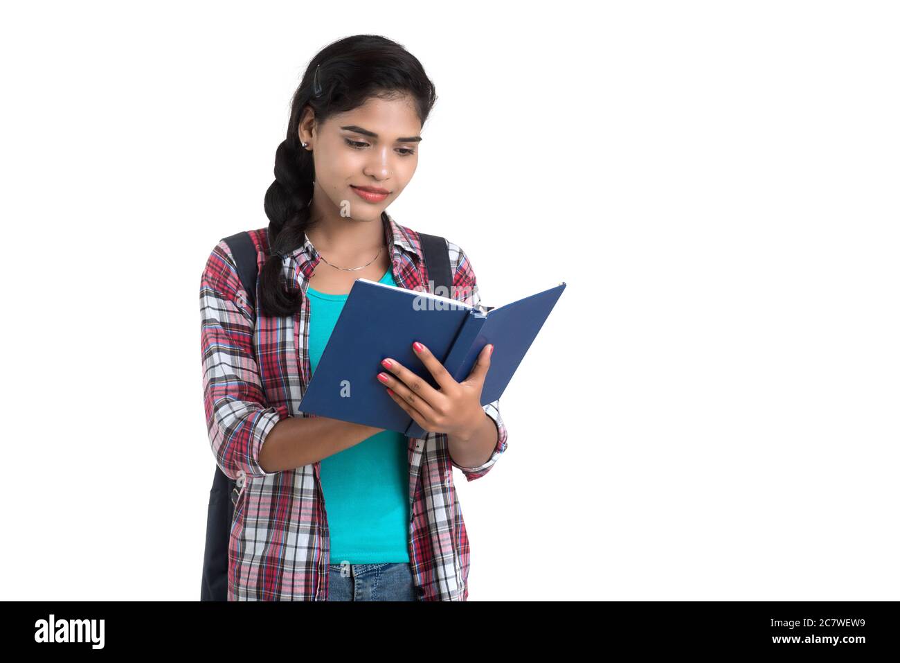 young Indian woman with backpack standing and holding notebooks, posing ...