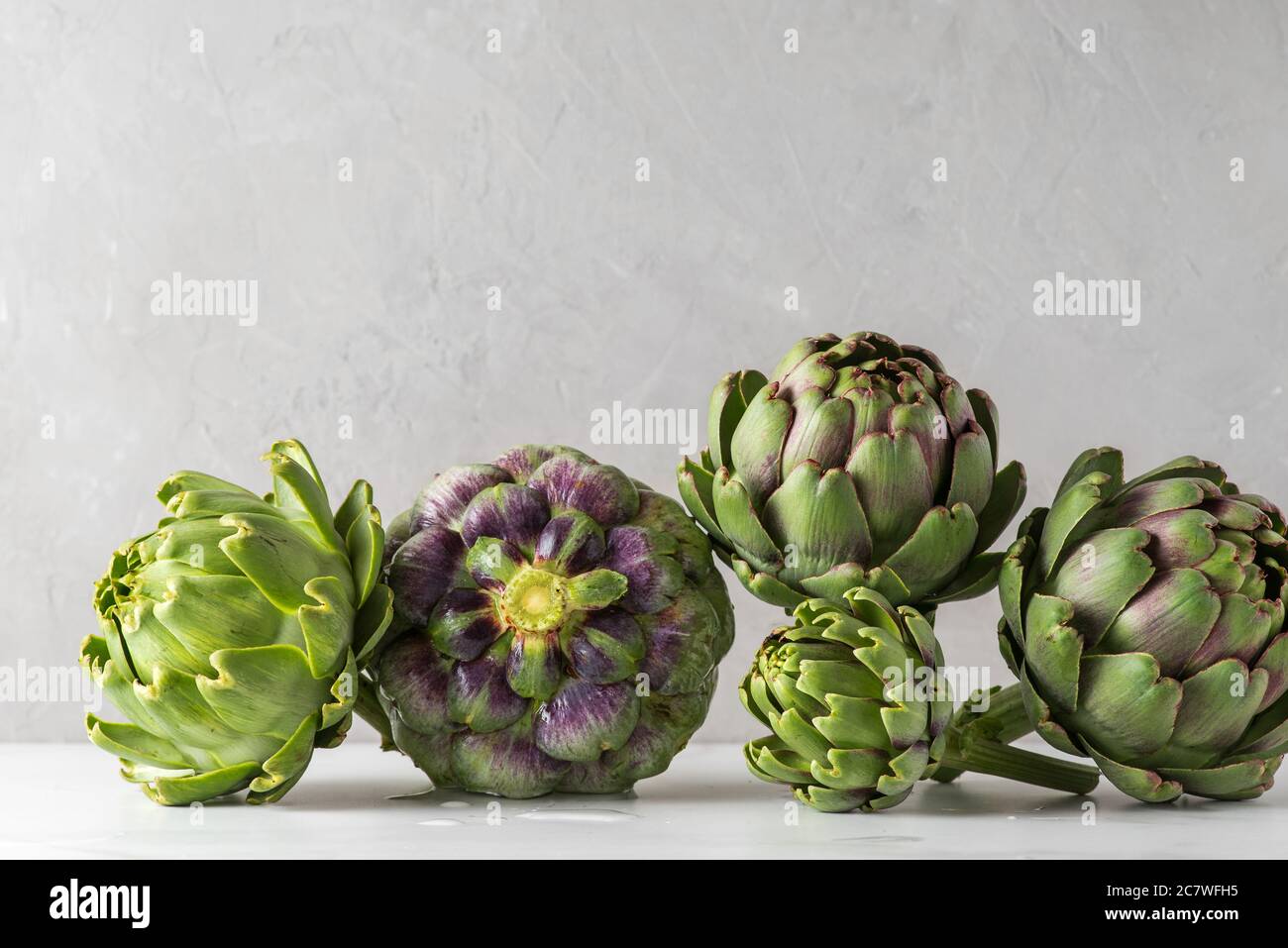Fresh ripe artichoke on concrete background. Healthy vegan food concept, close up Stock Photo