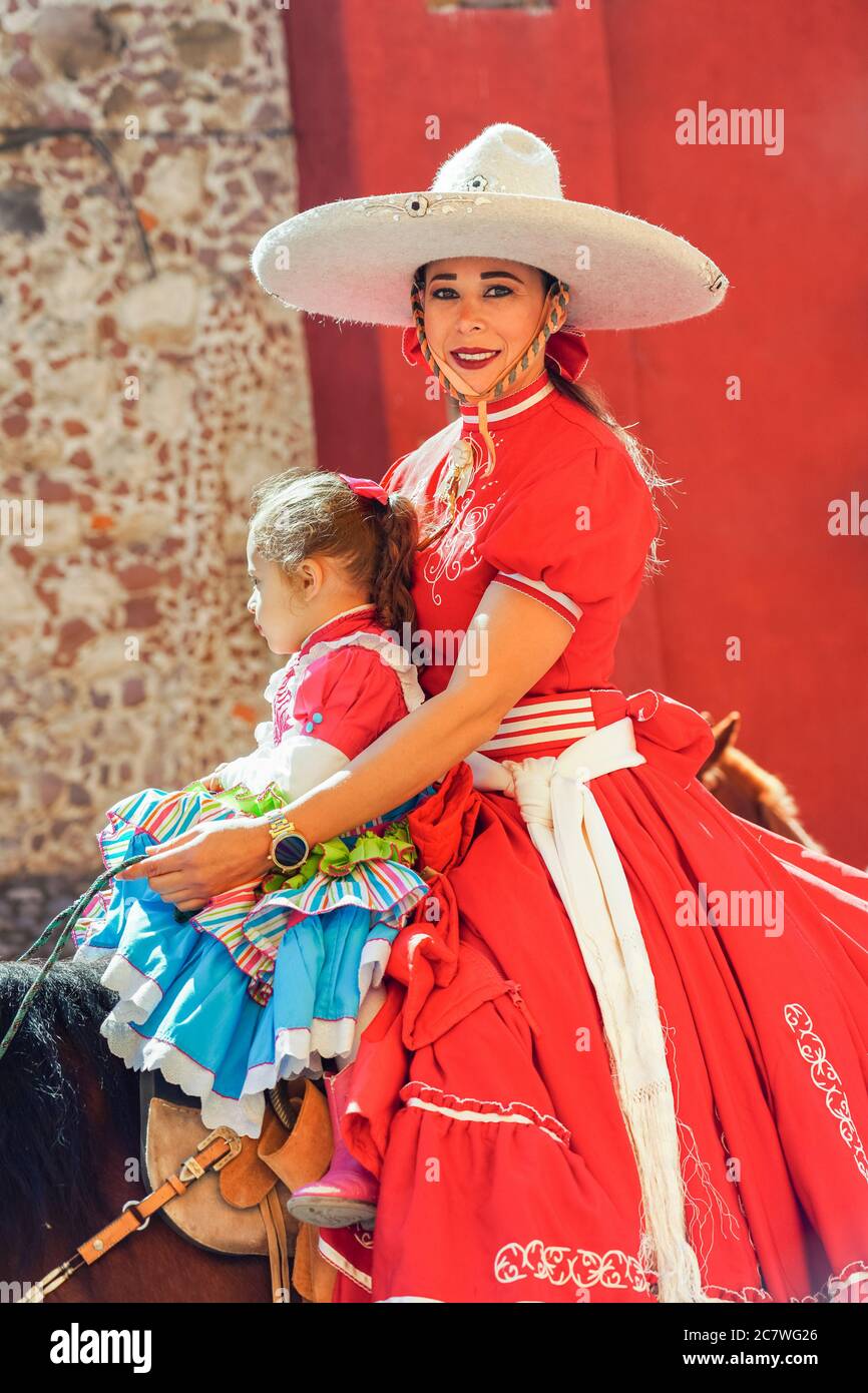 A Mexican Cowgirl and her daughter ride horseback in a parade to celebrate the 251st birthday of the Mexican Independence hero Ignacio Allende January 21, 2020 in San Miguel de Allende, Guanajuato, Mexico. Allende, from a wealthy family in San Miguel played a major role in the independency war against Spain in 1810 and later honored by his home city by adding his name. Stock Photo