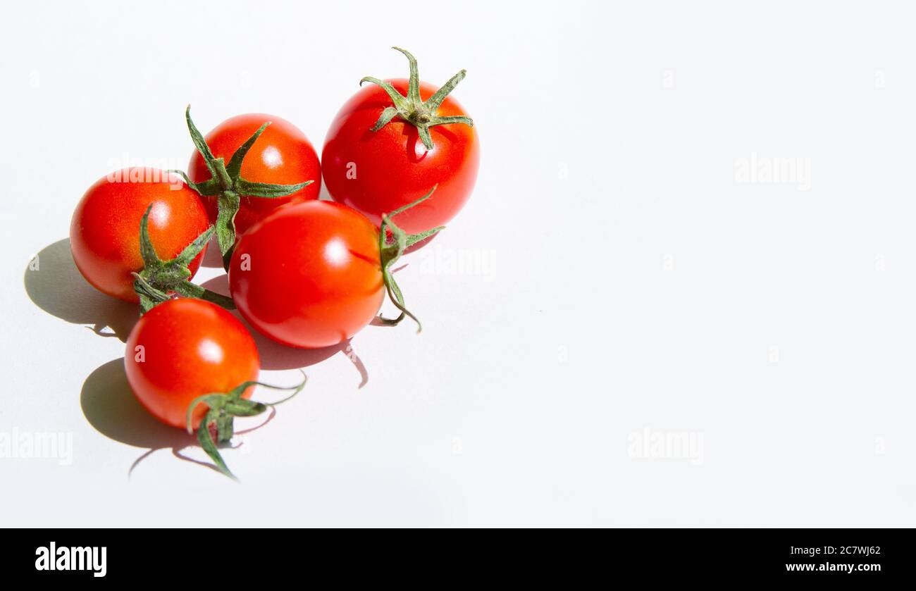 Red cherry tomatoes on a white background, arranged in a group.copyspace for text Stock Photo