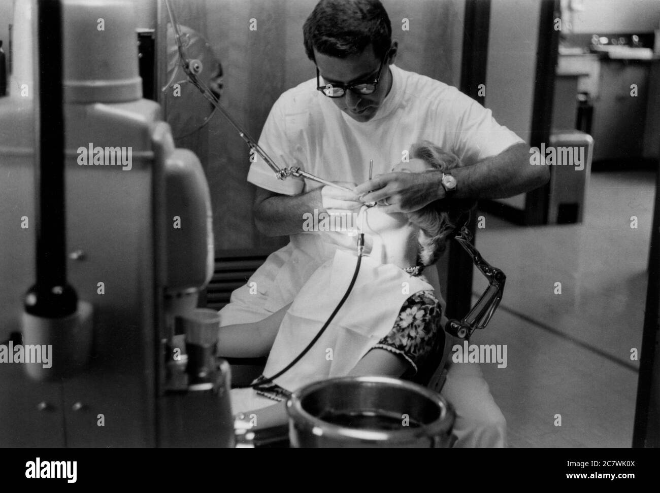 A dentist drilling a lady's tooth. Philadelphia 1960 Stock Photo