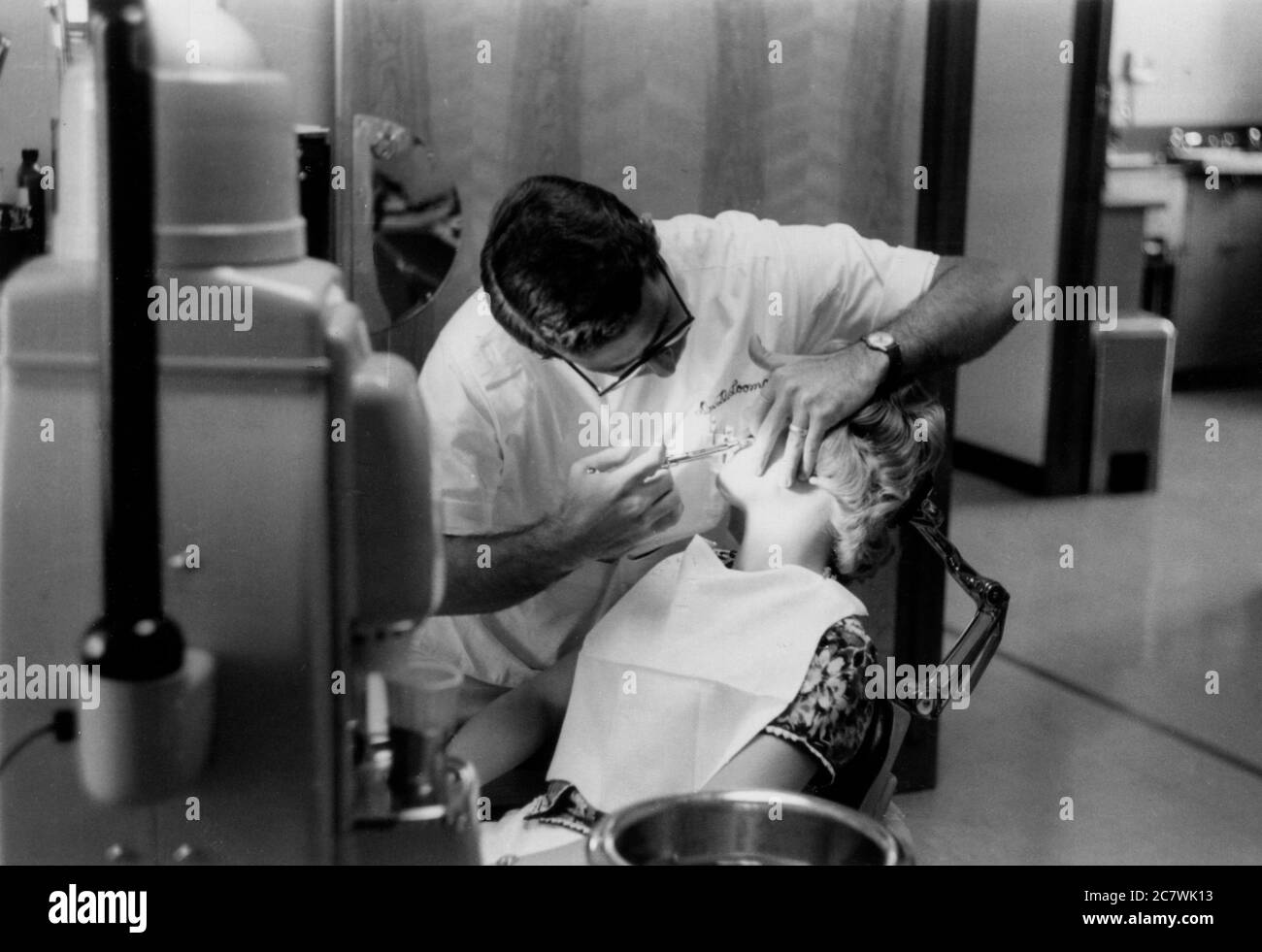 A dentist injecting a lady's gum with a syringe. Philadelphia 1960 Stock Photo