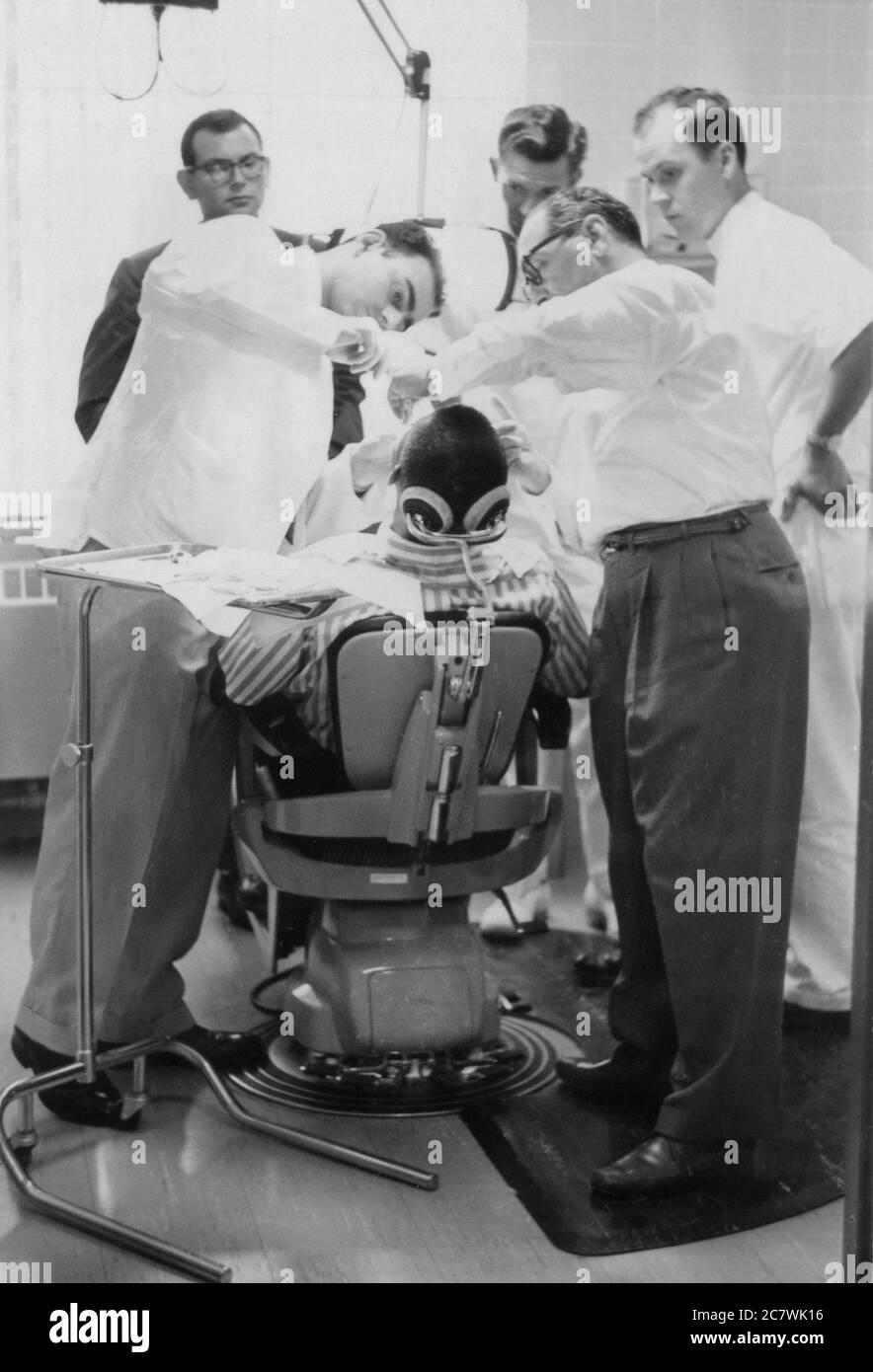 Two dentists attend to a patient while others look. Philadelphia 1960. Stock Photo