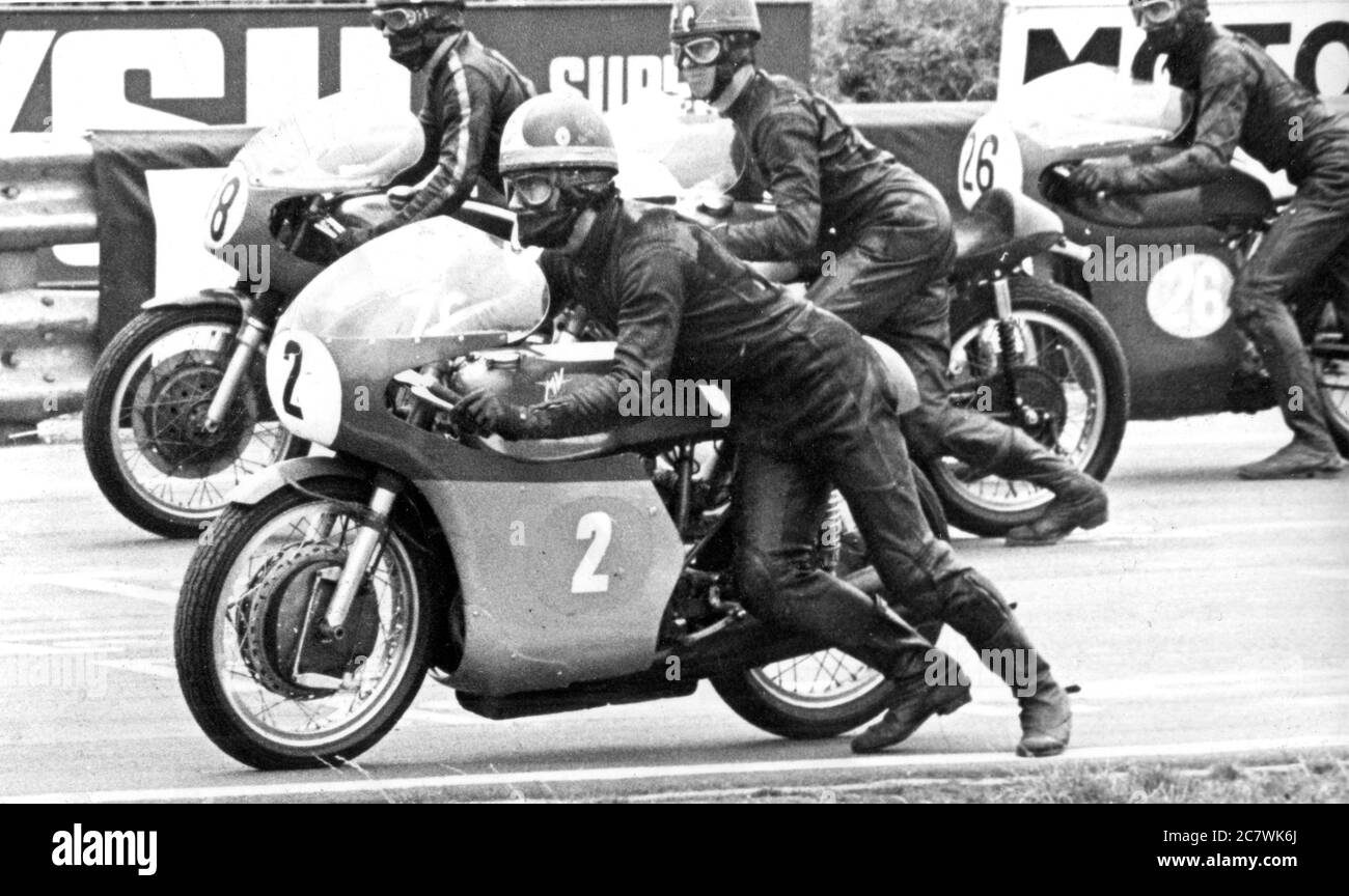The start of a motorcycle race, circa 1968. The competitor in the foreground is riding an Italian made MV Agusta bike. The riders are push–starting their motorcycles. Stock Photo