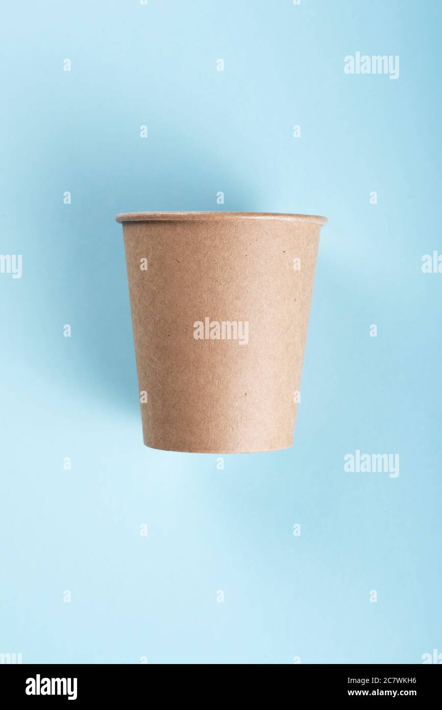 Brown coffee cup isolated on light blue background.  Stock Photo
