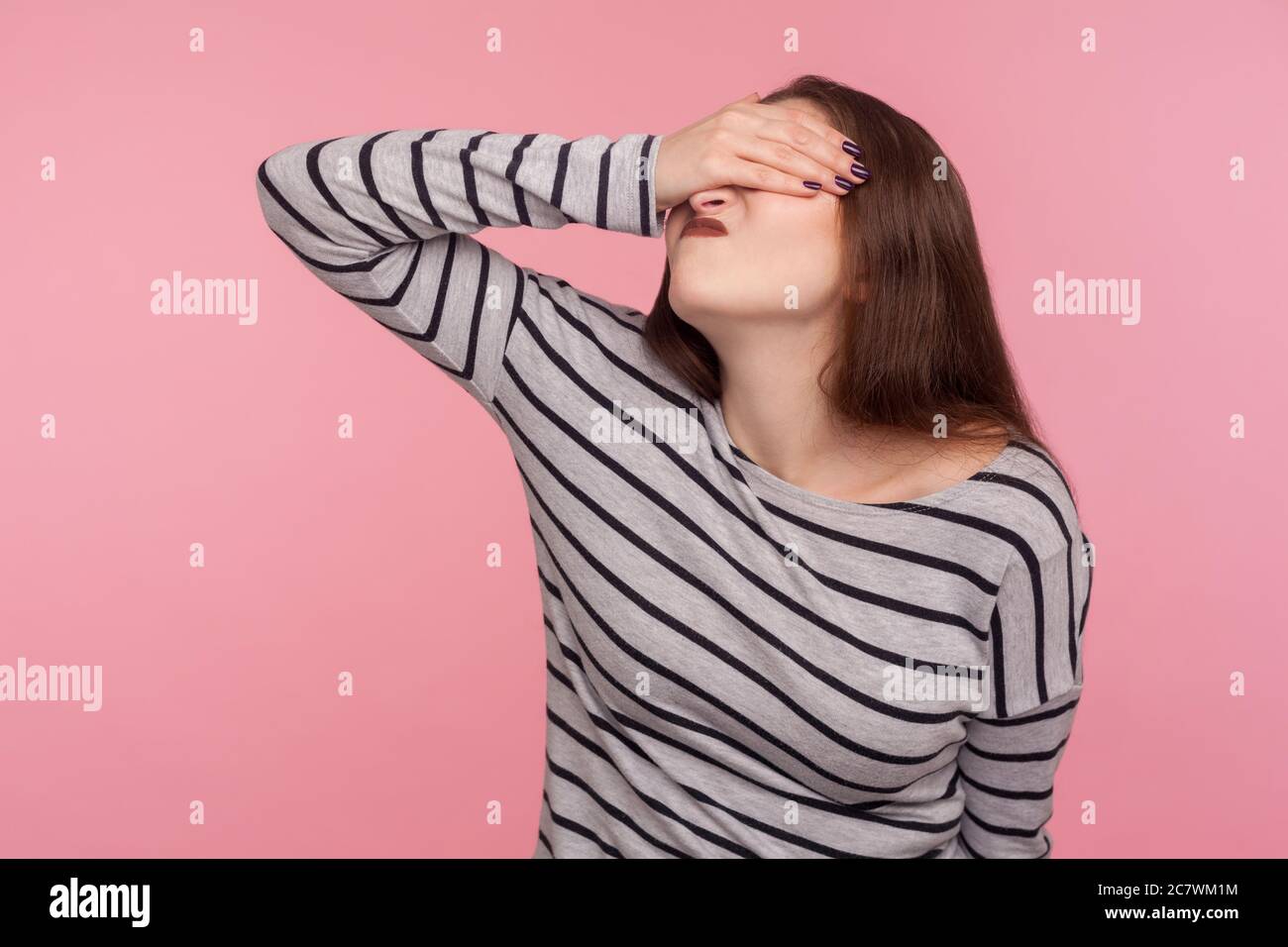 Don't want to look at this! Portrait of woman in striped sweatshirt covering eyes and turning with disgust from something shameful, scared to watch. i Stock Photo