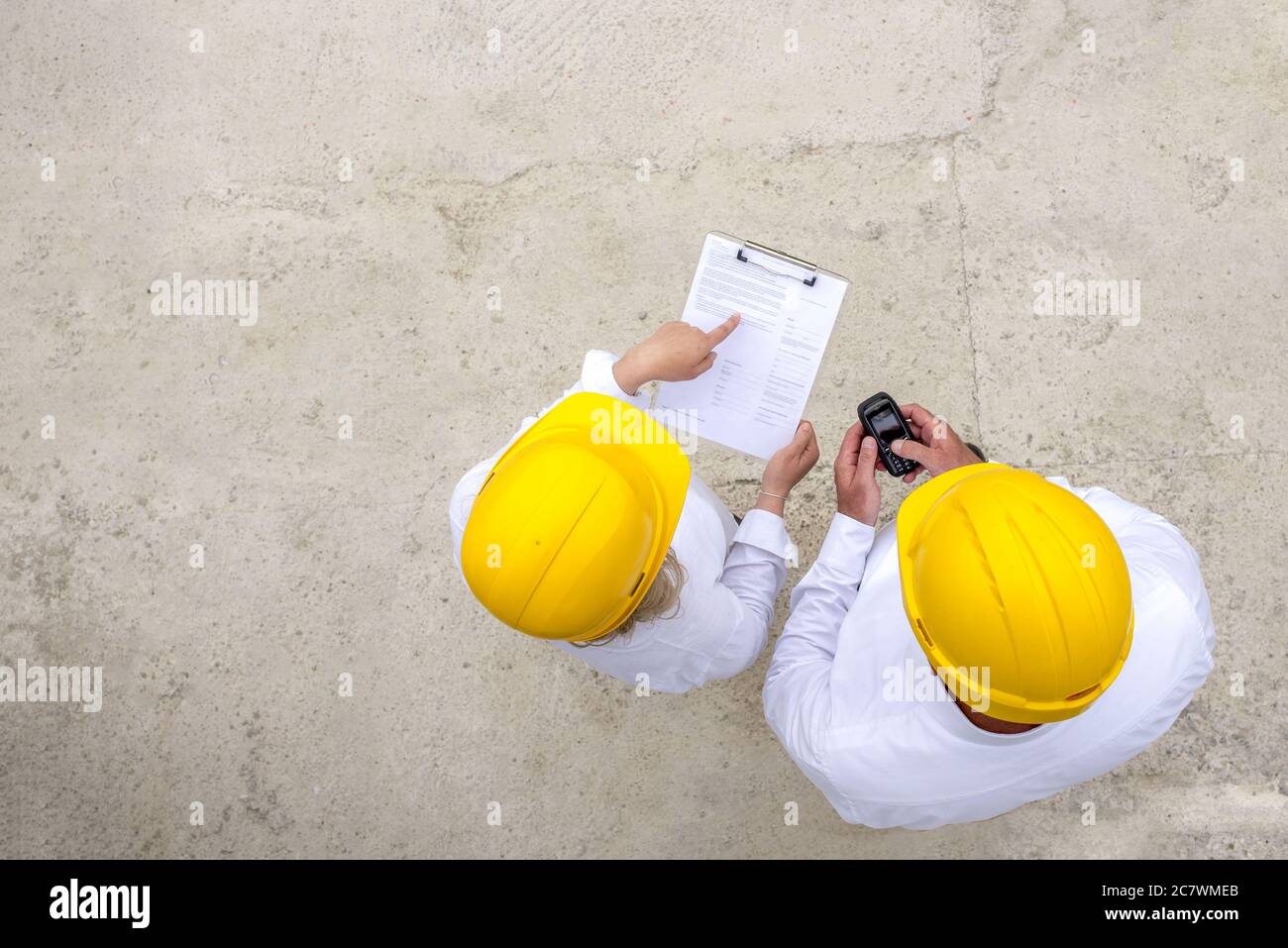 Overhead shot of two engineers wearing hard hats discussing work Stock Photo Alamy