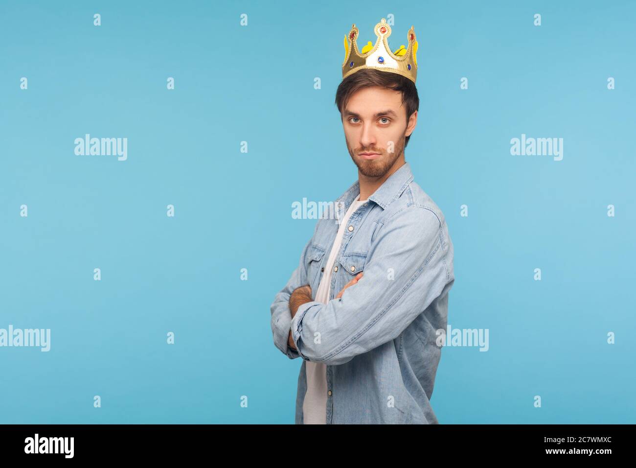 I'm king! Portrait of confident ambitious man wearing golden crown, looking with arrogance, declaring his authority and leadership, superior privilege Stock Photo