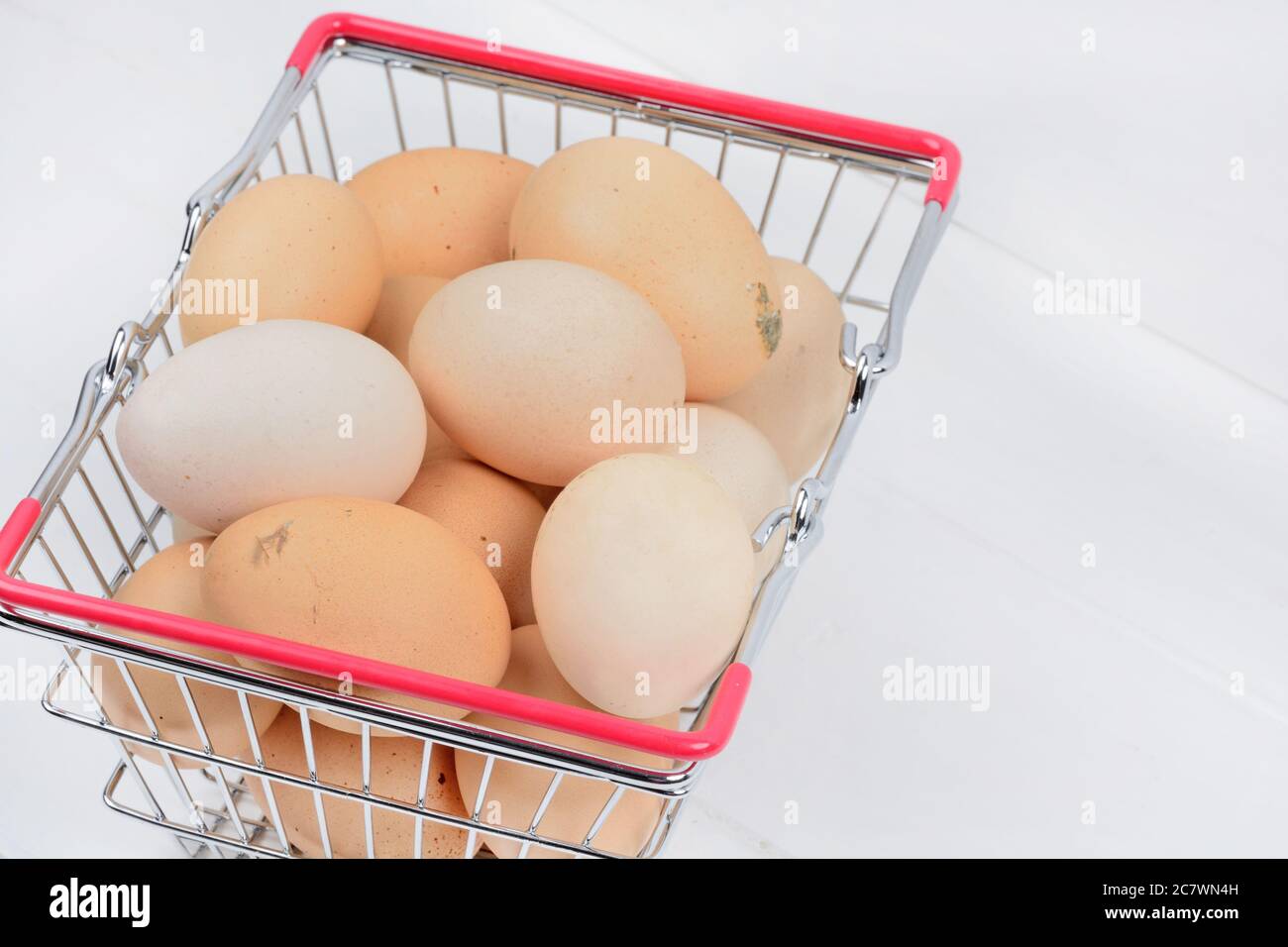 Many eggs in a shopping cart on a wood table close up Stock Photo