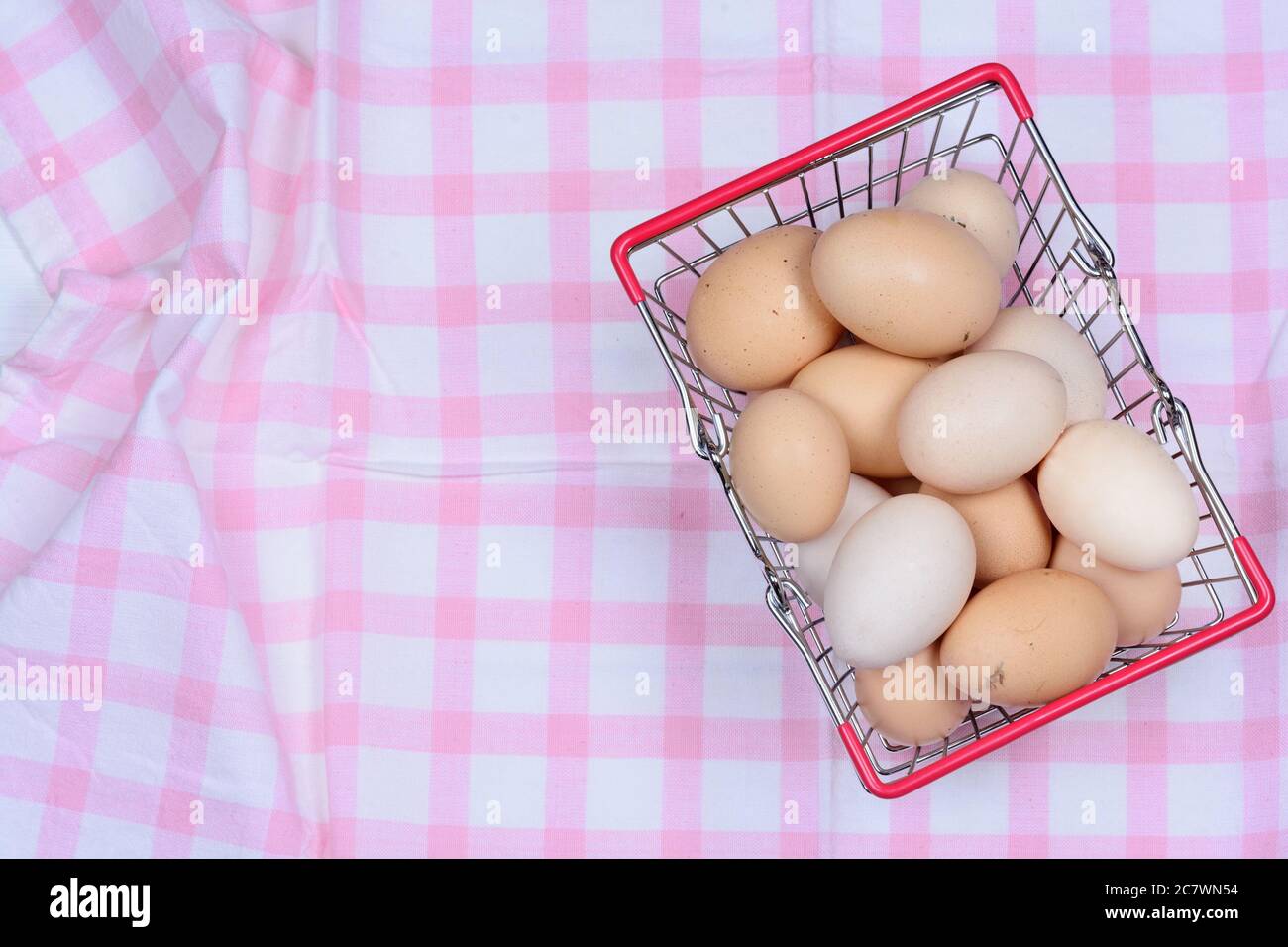 Stack of eggs in a shopping cart on table Stock Photo