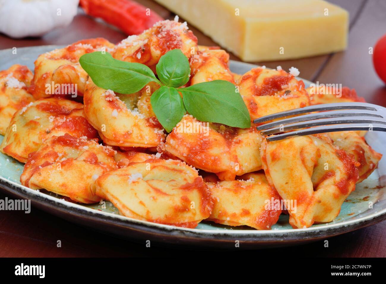 Tortellini with tomatoes sauce in a plate on table Stock Photo