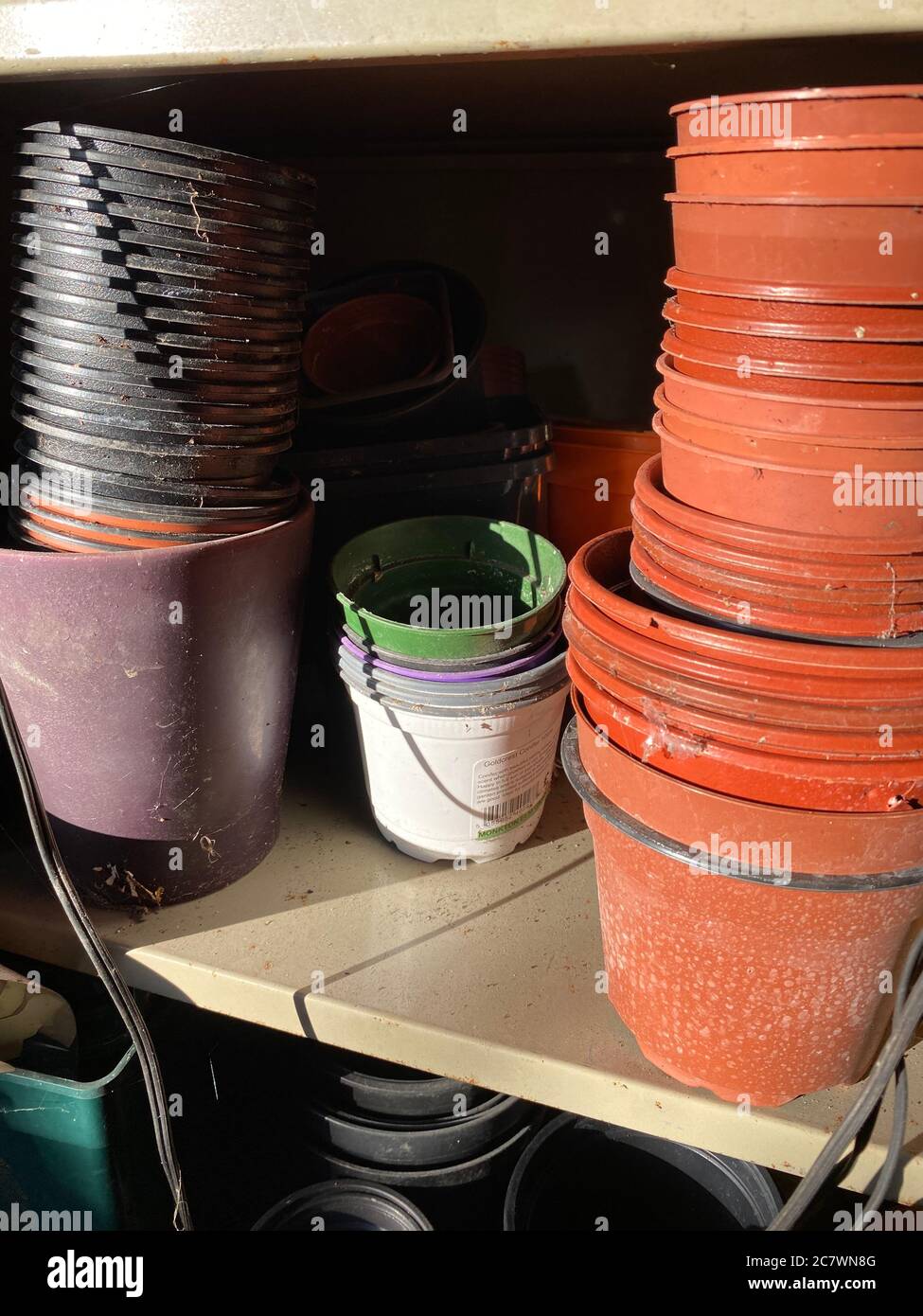 Empty Plant Pots stacked on a shelf in a English garden shed. Stock Photo