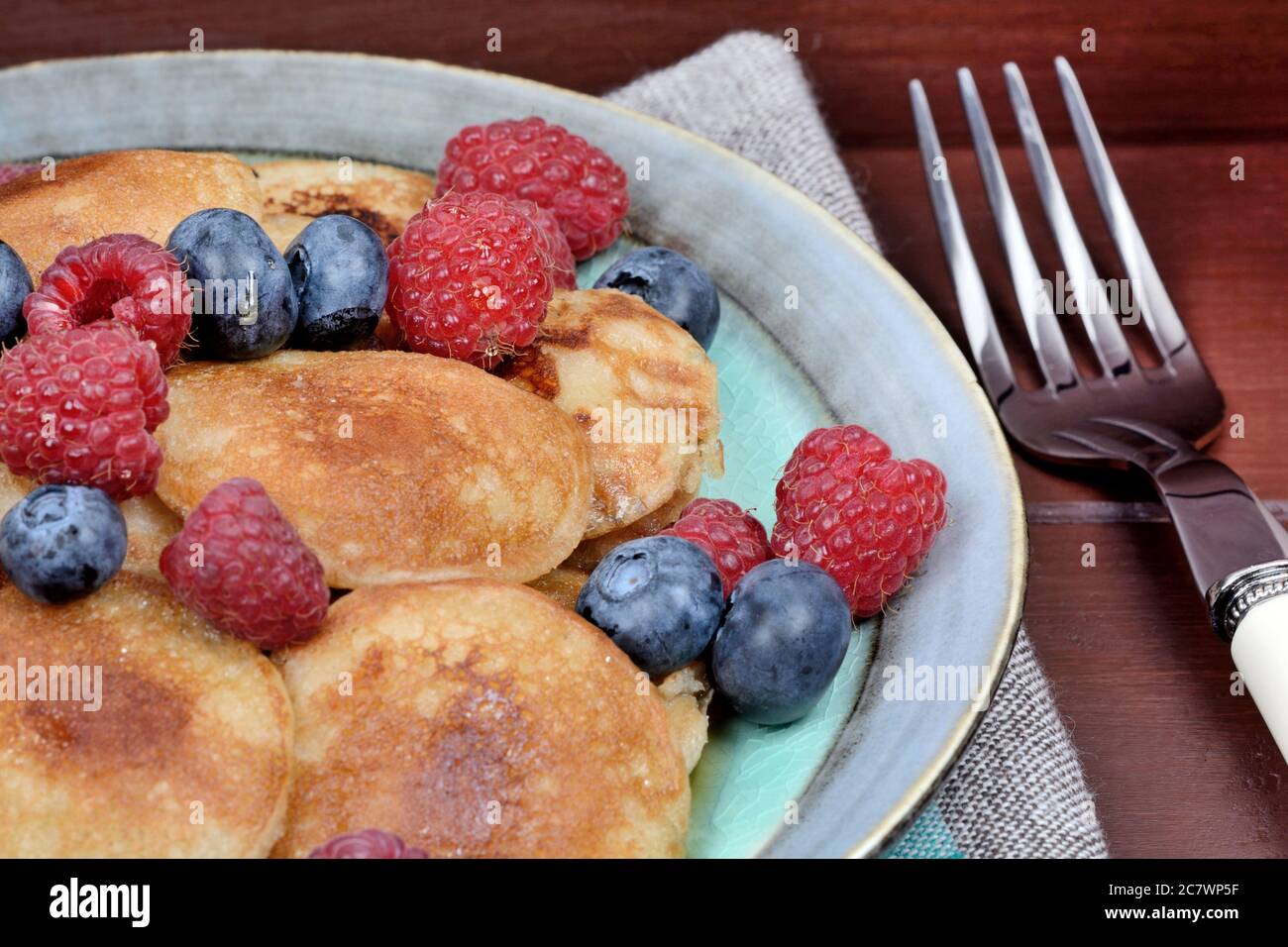 Mini pancakes with raspberries and cranberries on table Stock Photo