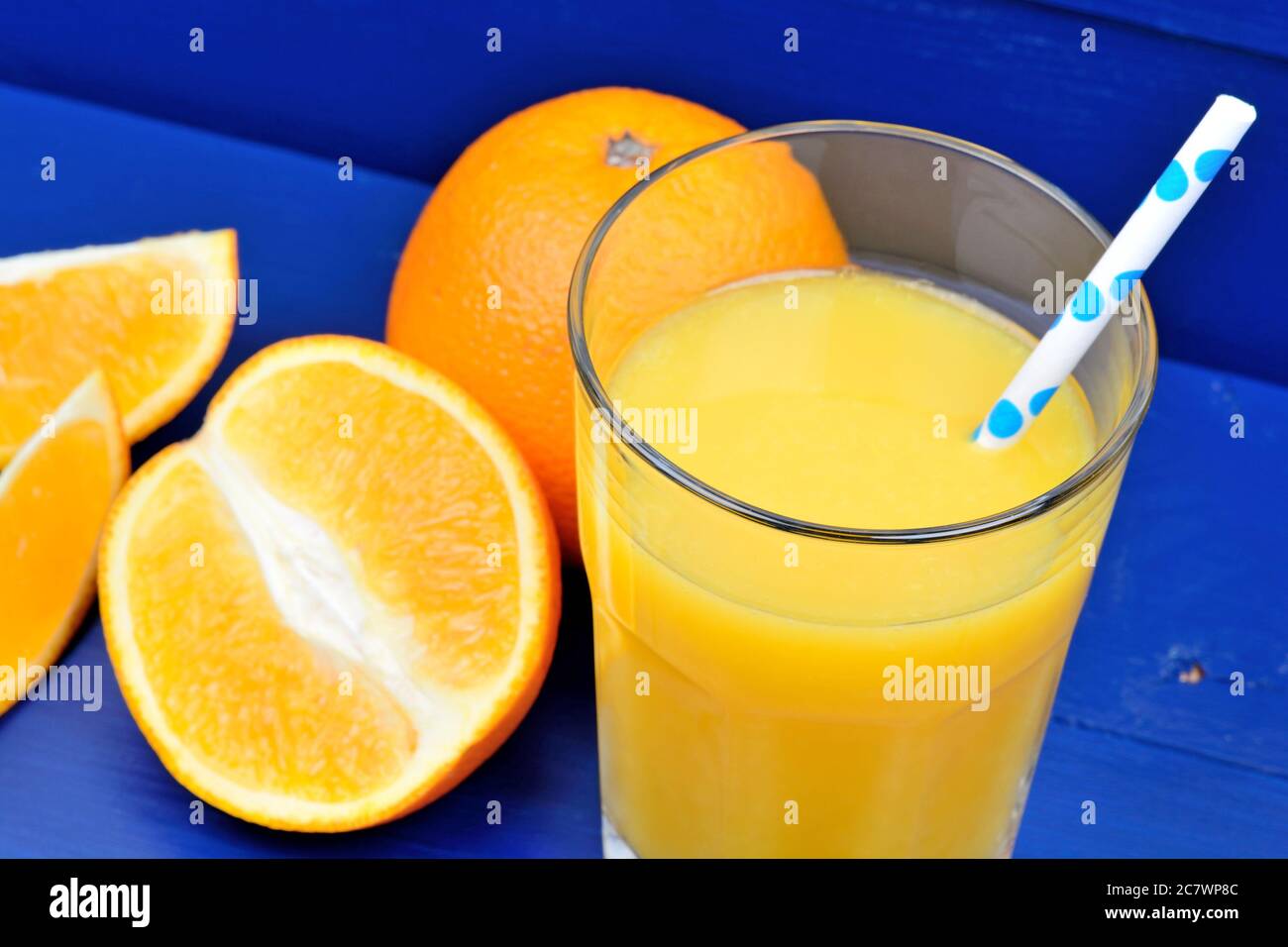 Healthy orange juice in a glass on blue wooden table Stock Photo