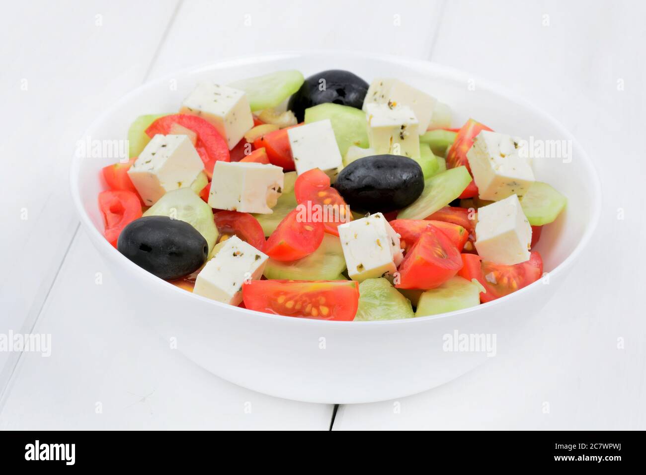Vegetables with cheese in a bowl on white wooden table Stock Photo