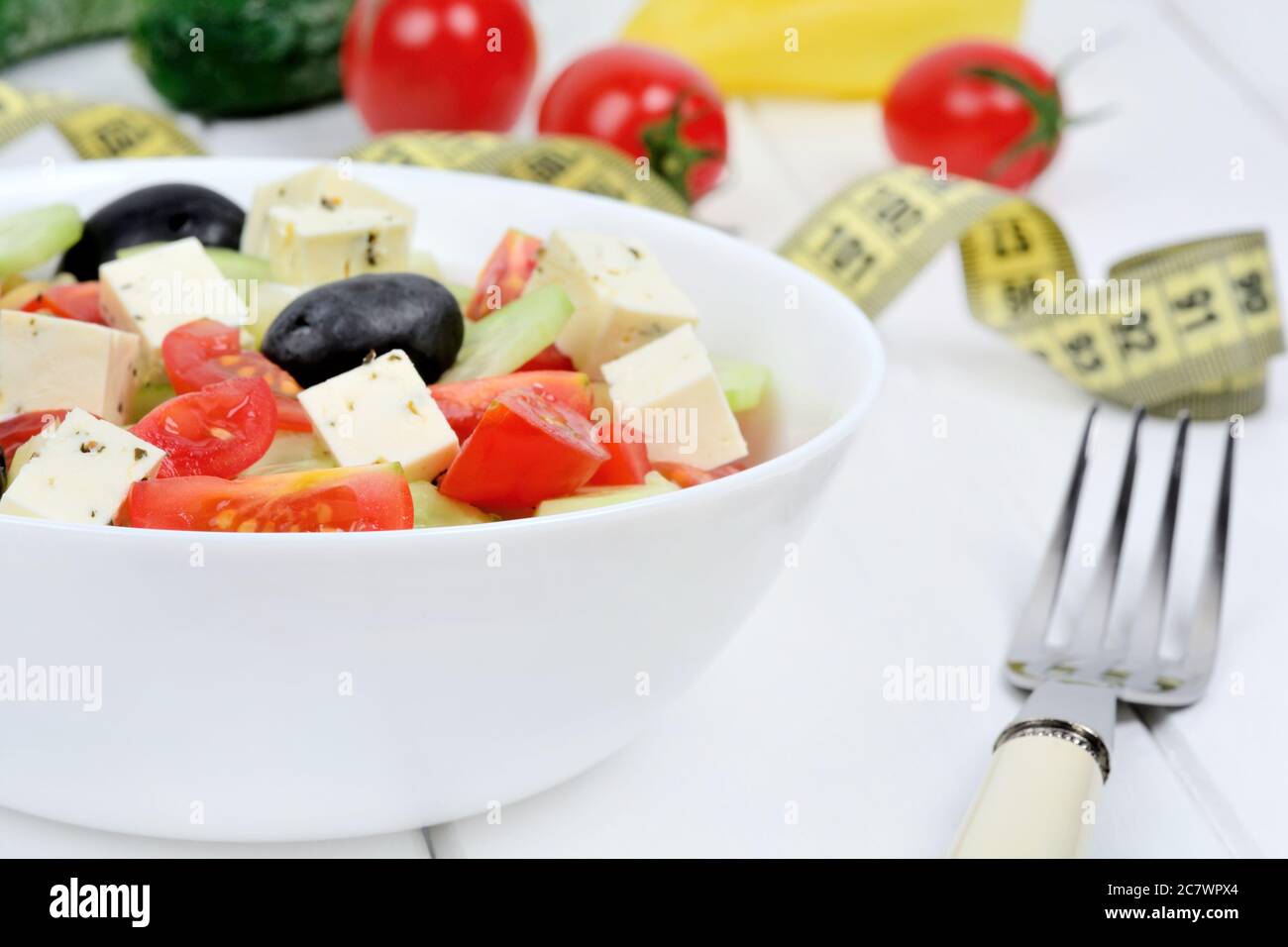 Vegetables salad with cheese in a bowl and centimeter on wooden table Stock Photo