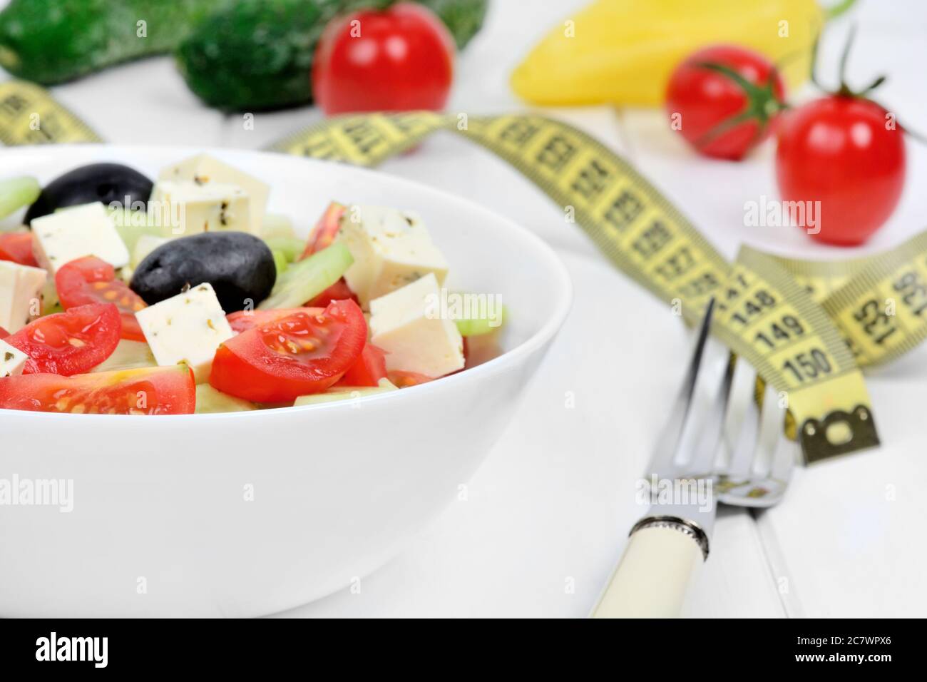 Vegetables salad in a bowl with centimeter on white wood table Stock Photo