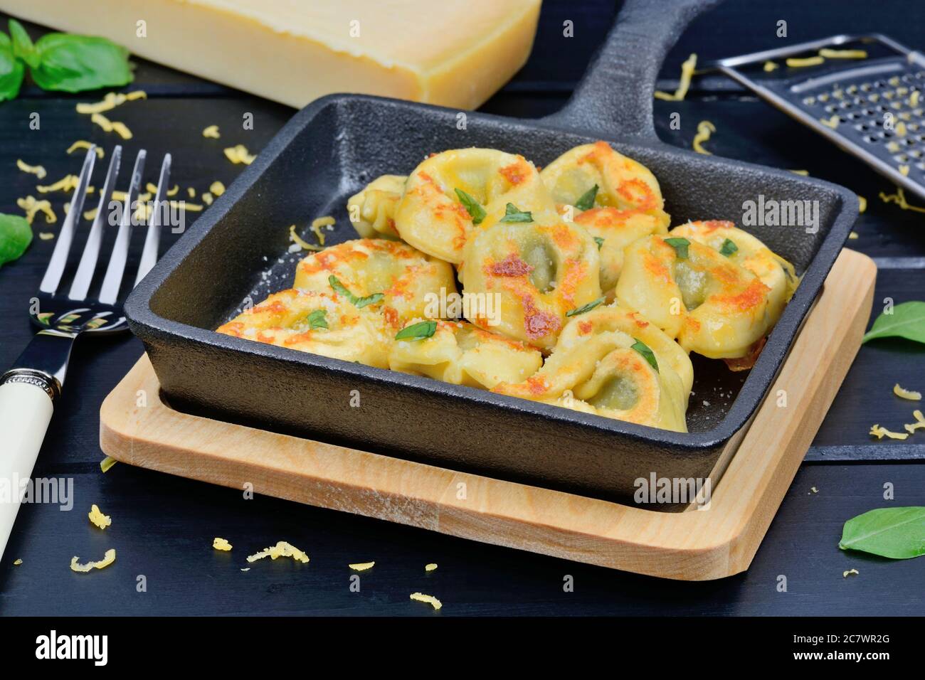 Close up of tortellini in a iron pan on cutting board Stock Photo