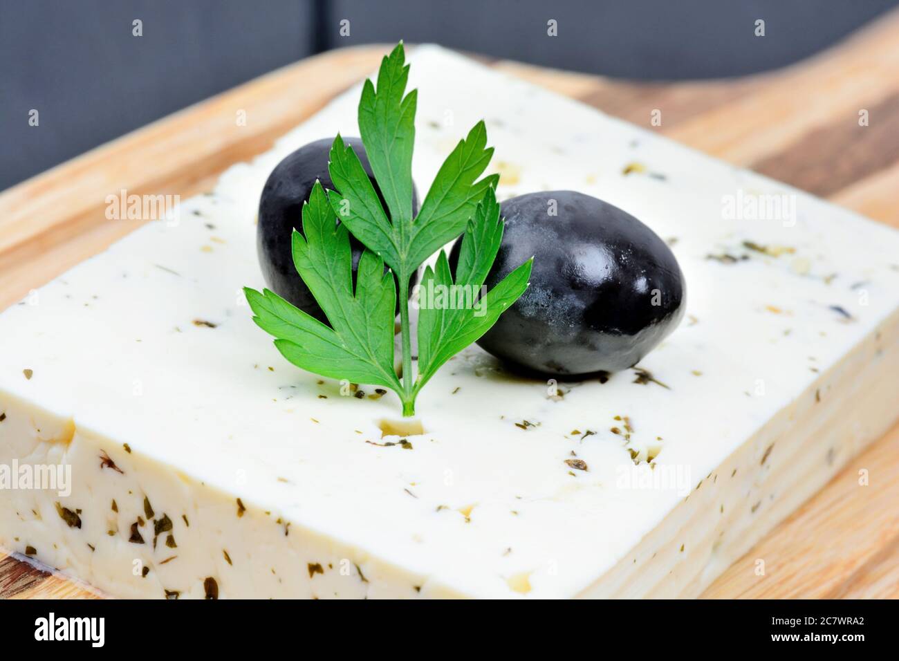 Close up of herbs cheese with olive on a cutting board Stock Photo