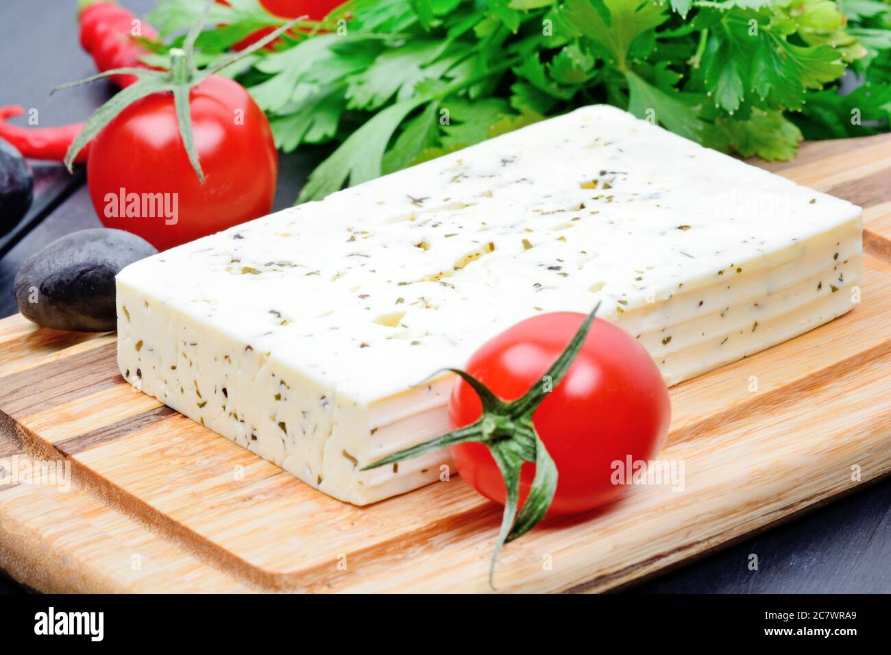 Herbs cheese with olive and cherry tomatoes on a wood table Stock Photo