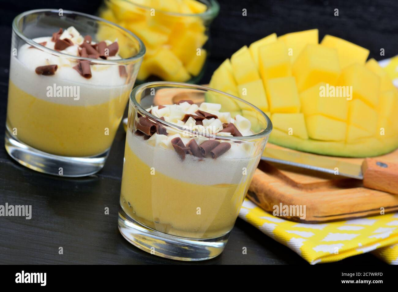 Pudding of mango in a glasses jars on a black wooden table Stock Photo