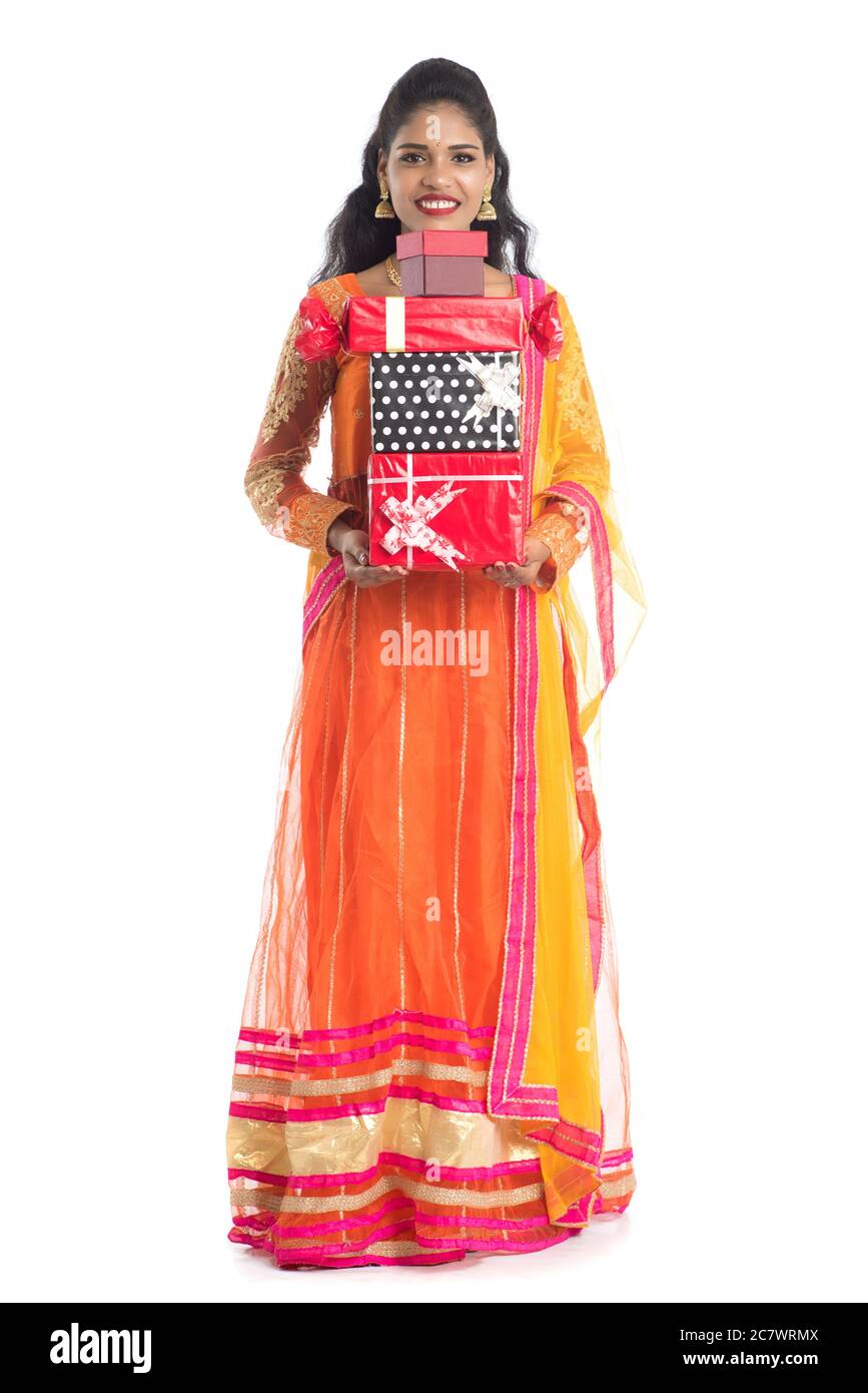 Portrait of young happy smiling Indian Girl holding gift boxes on a ...