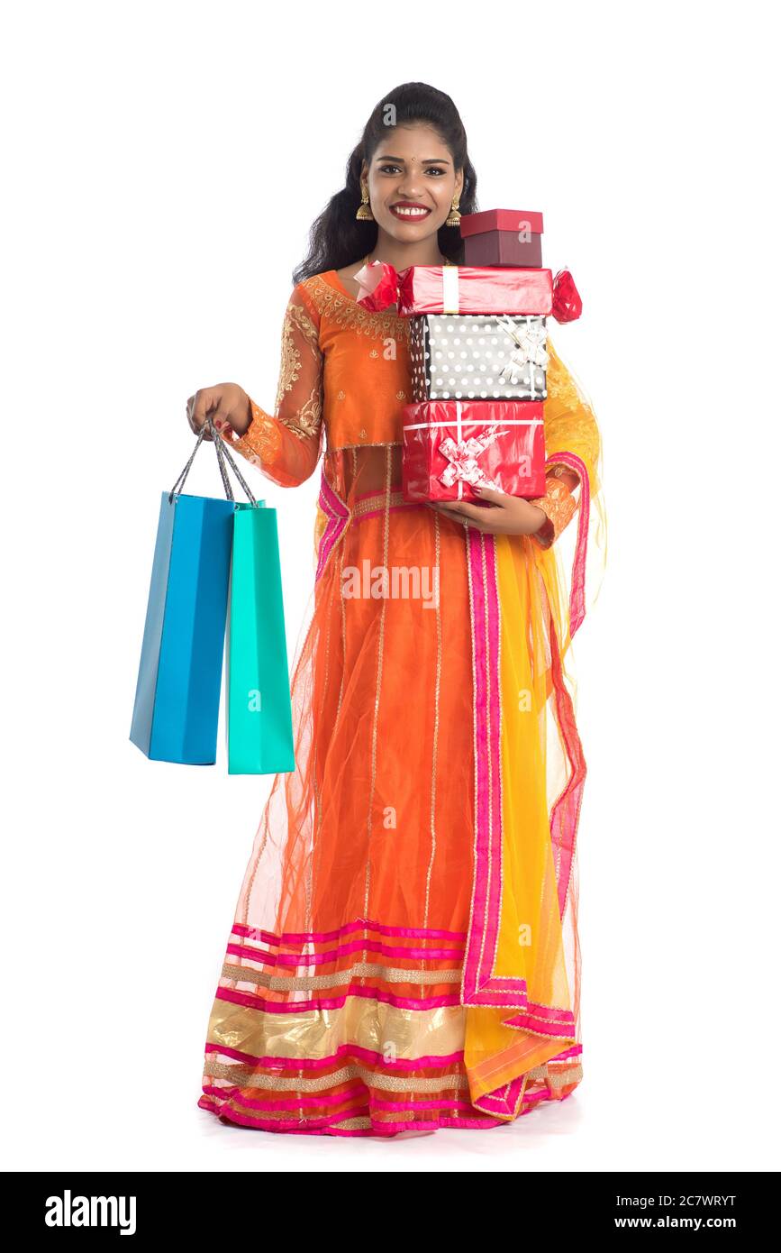Beautiful woman carrying many shopping bags and gift Box on a white