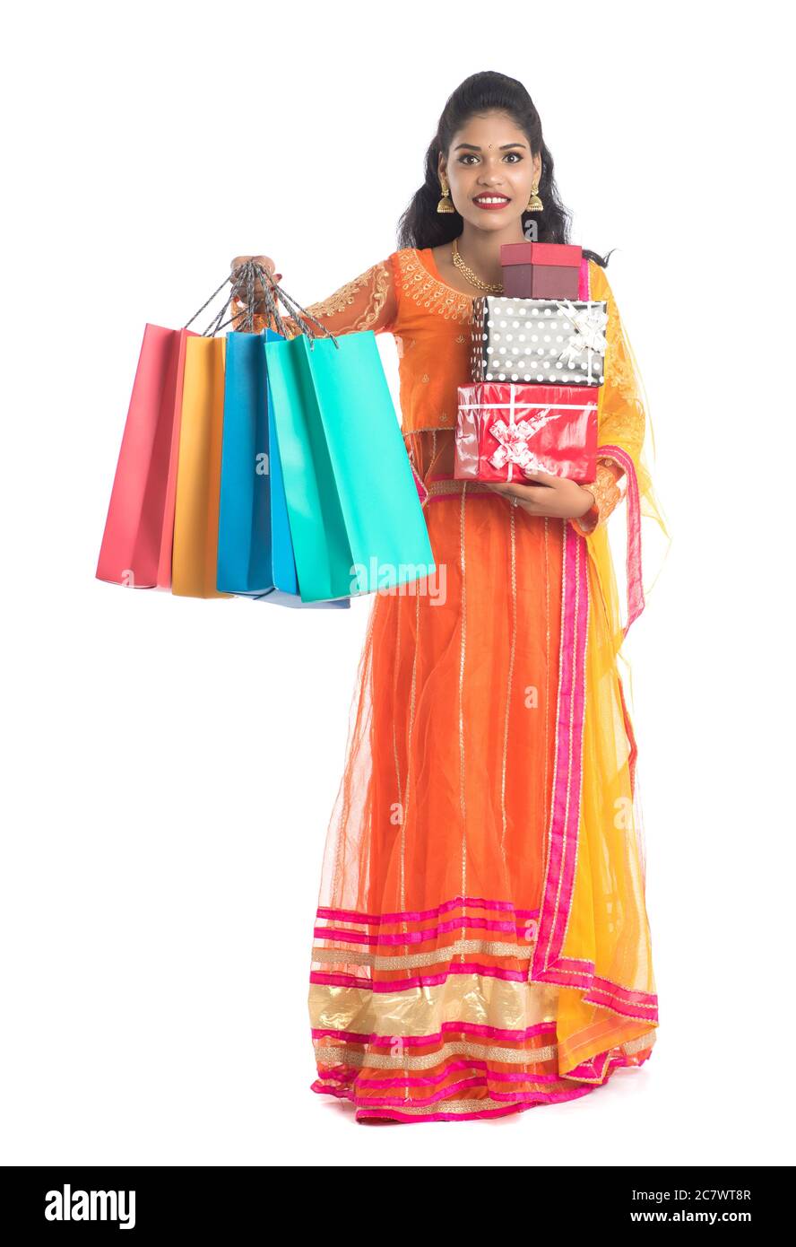 Beautiful woman carrying many shopping bags and gift Box on a white