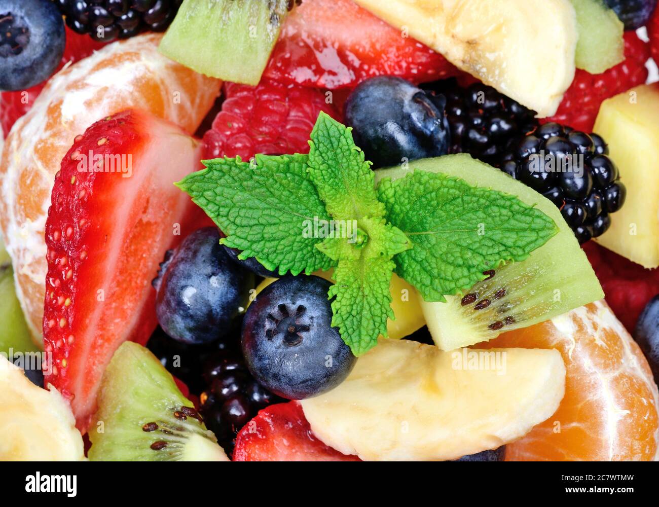 Close up of top view of a fruit salad with strawberries, oranges, kiwi, blueberries and bananas Stock Photo
