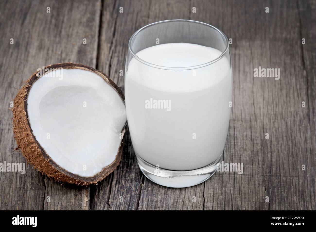 Coconut milk in a glass on old wood table Stock Photo