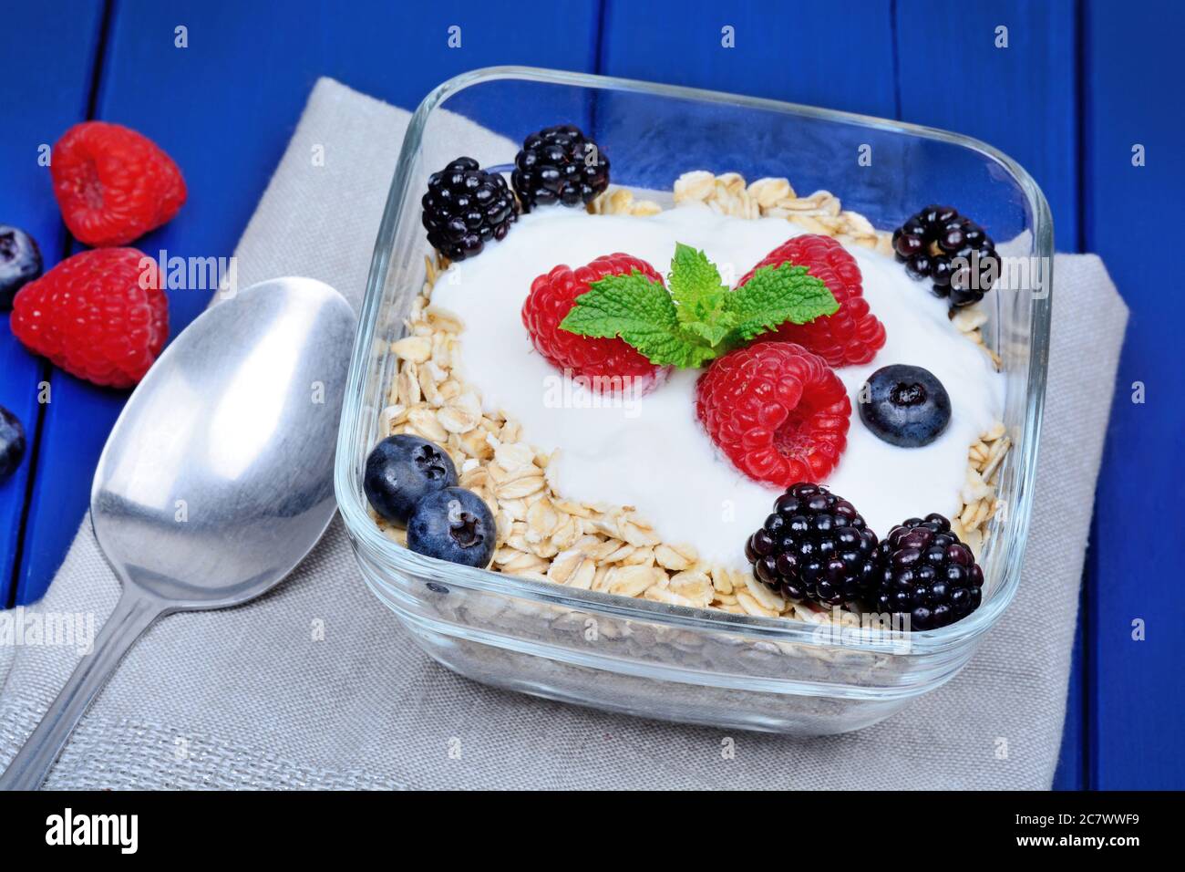 Oat with yogurt and berries in a bowl on wooden table Stock Photo