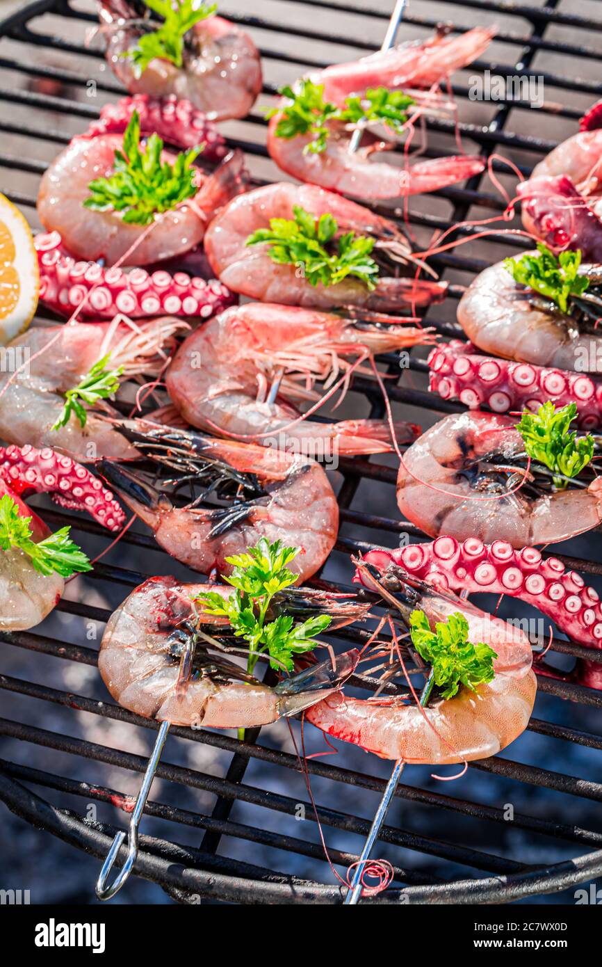Top view of grilling seafood skewers with prawn and octopus Stock Photo