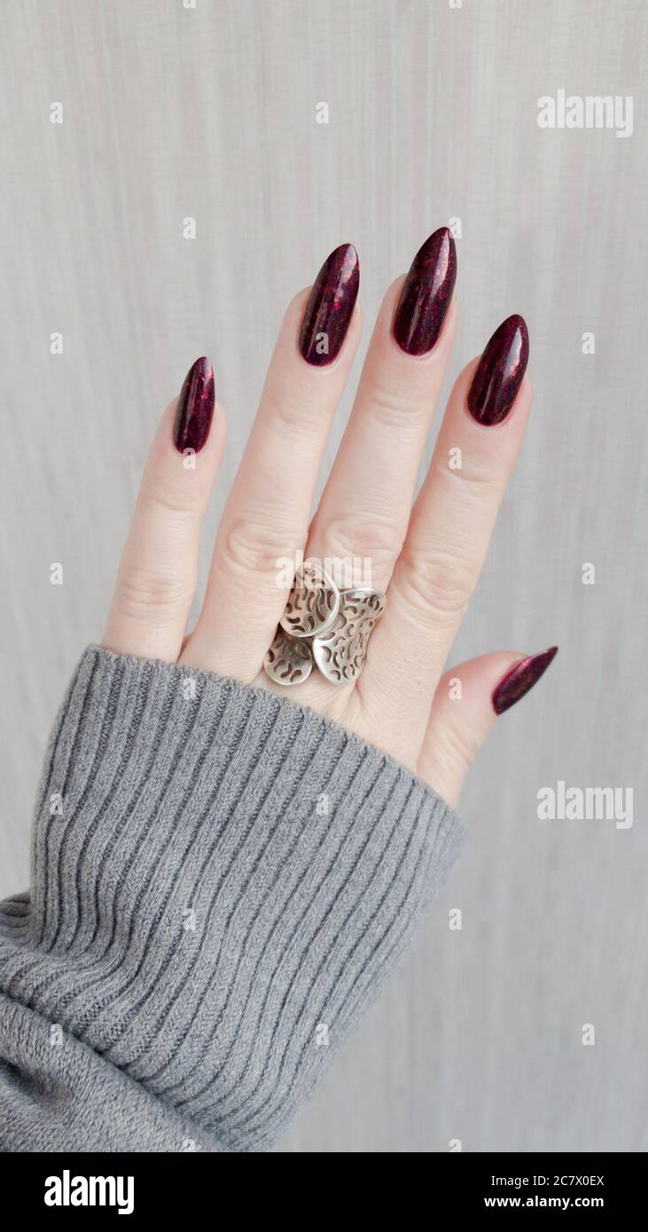 Female Hand With Long Nails And A Bottle Of Dark Red Nail Polish Stock  Photo, Picture and Royalty Free Image. Image 153531487.
