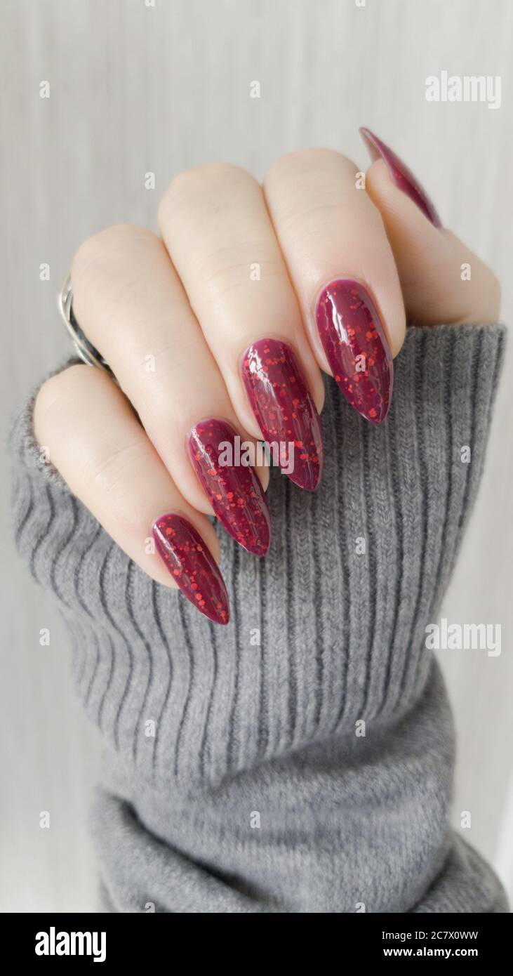 Female Hand With Long Nails And A Bottle Of Dark Red Nail Polish Stock Photo Alamy
