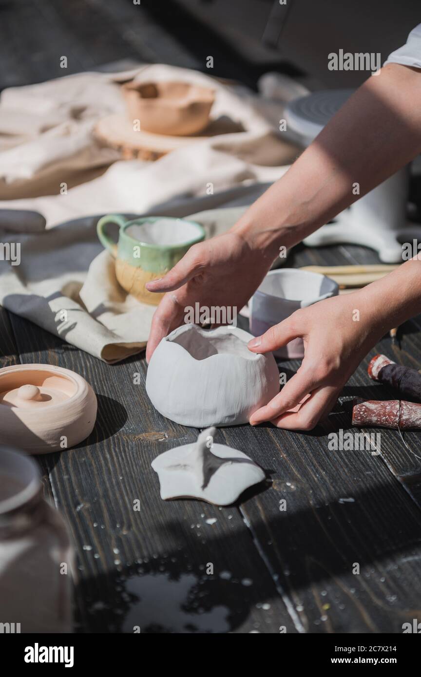 Female potter making ceramic dishes at her studio. Working process of