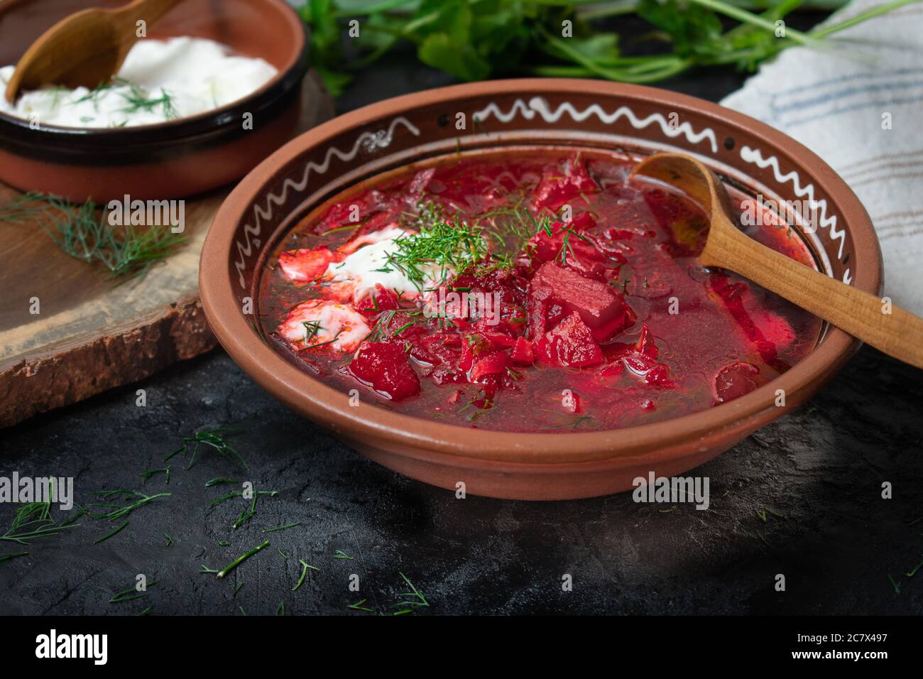 Vegetarian borstch served in traditional clay bowl on dark background Stock Photo