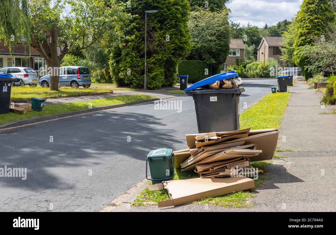 Roadside recycling wheelie bins and overflowing cardboard packaging