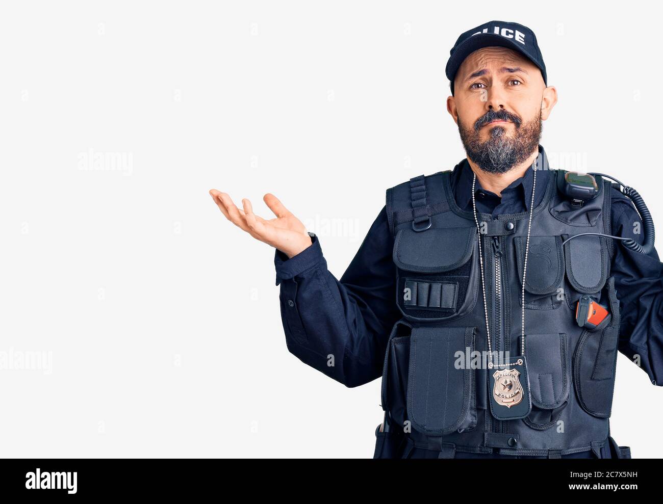 Young handsome man wearing police uniform clueless and confused expression with arms and hands raised. doubt concept. Stock Photo