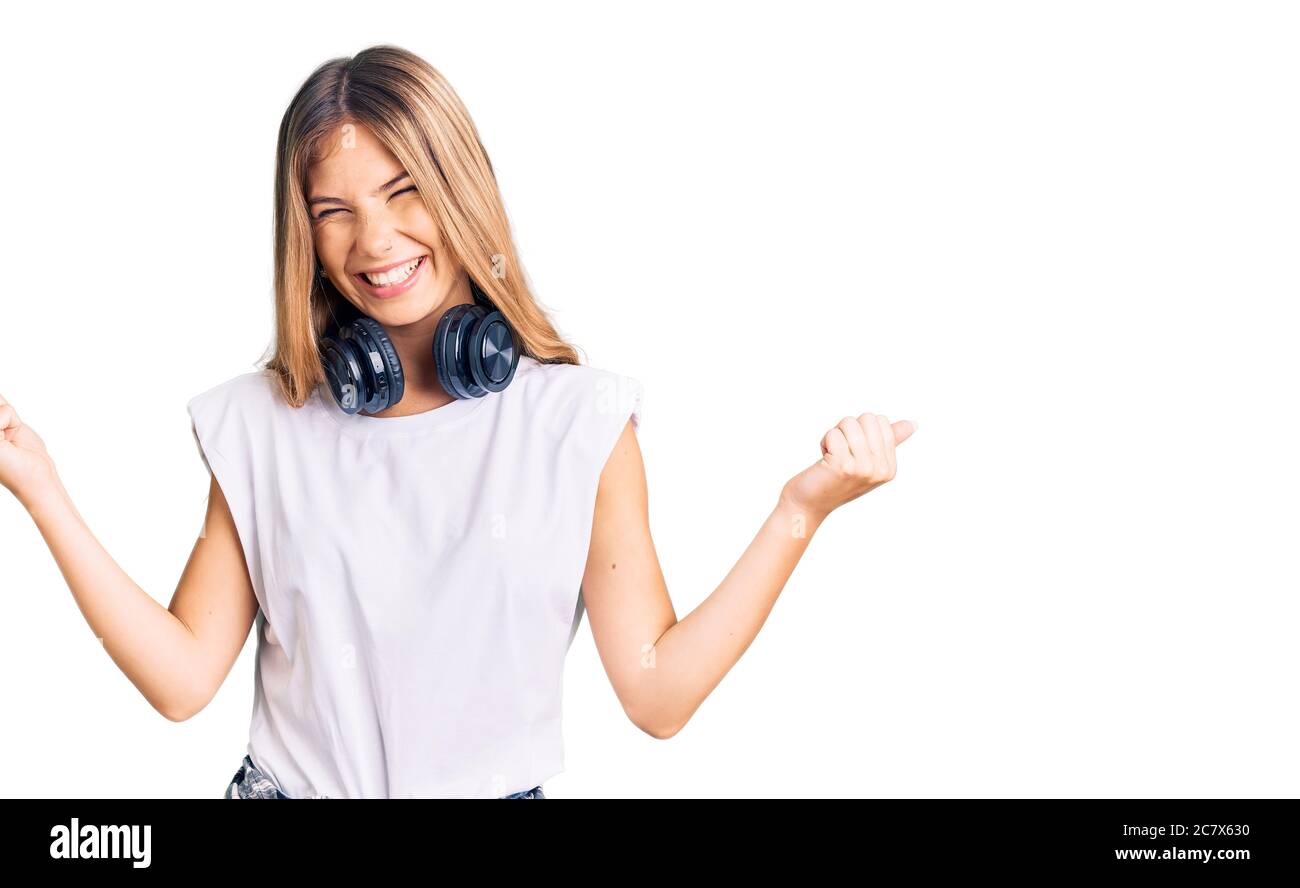 Beautiful caucasian woman with blonde hair listening to music wearing ...