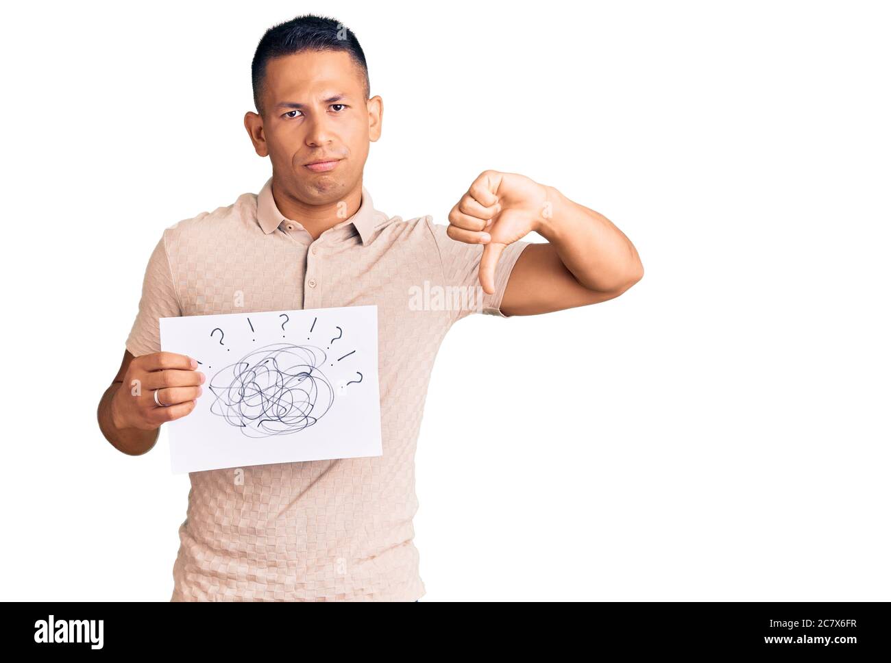 Young handsome latin man holding scribble draw with angry face, negative sign showing dislike with thumbs down, rejection concept Stock Photo