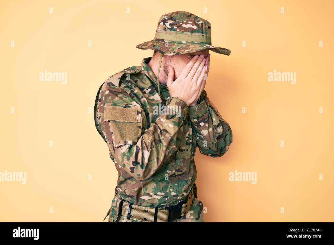 Young caucasian man wearing camouflage army uniform with sad expression ...