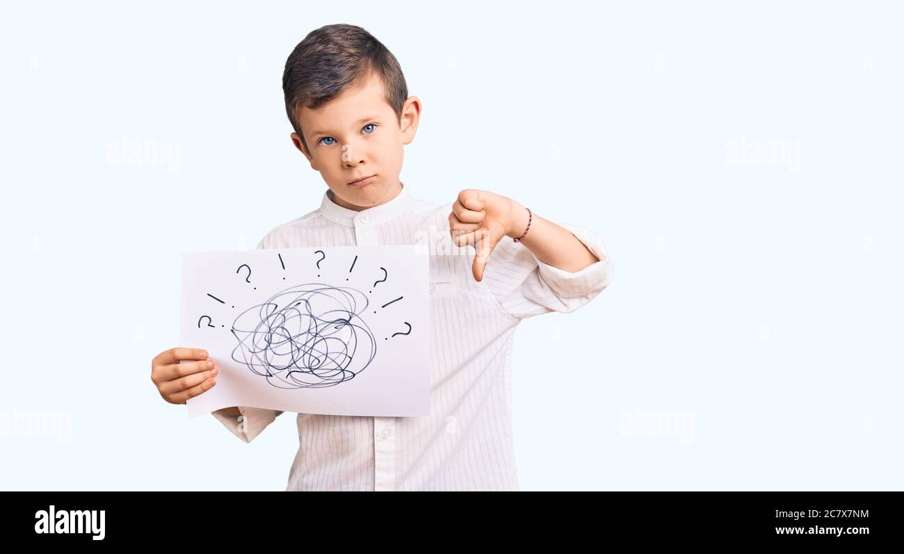 Cute blond kid holding scribble draw with angry face, negative sign showing dislike with thumbs down, rejection concept Stock Photo